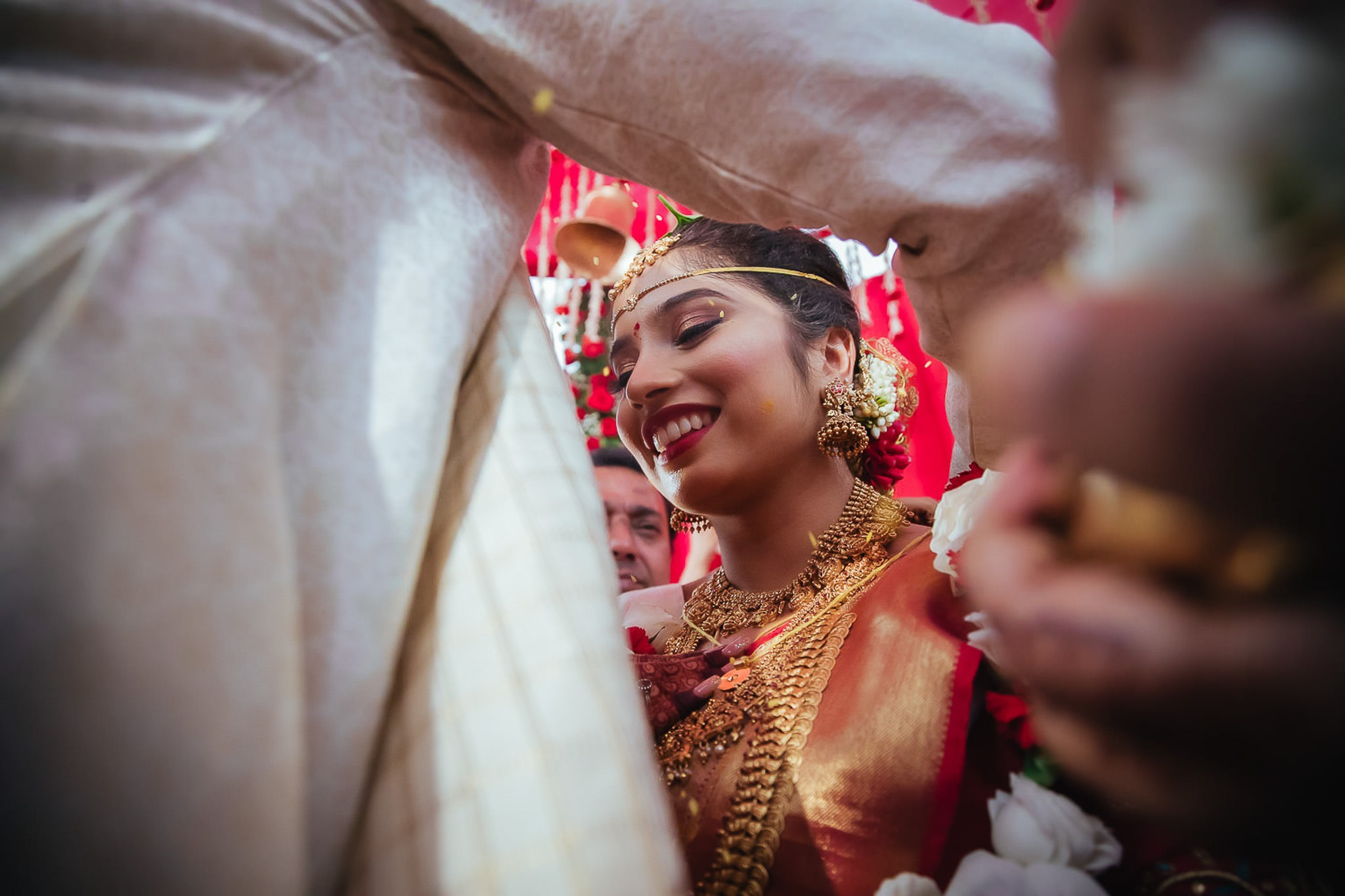 An moment where the bride smiles while Thali being tied at Kannada wedding.