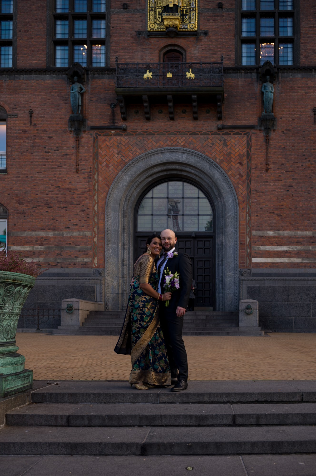 Bride and groom walking through historic City Hall doors