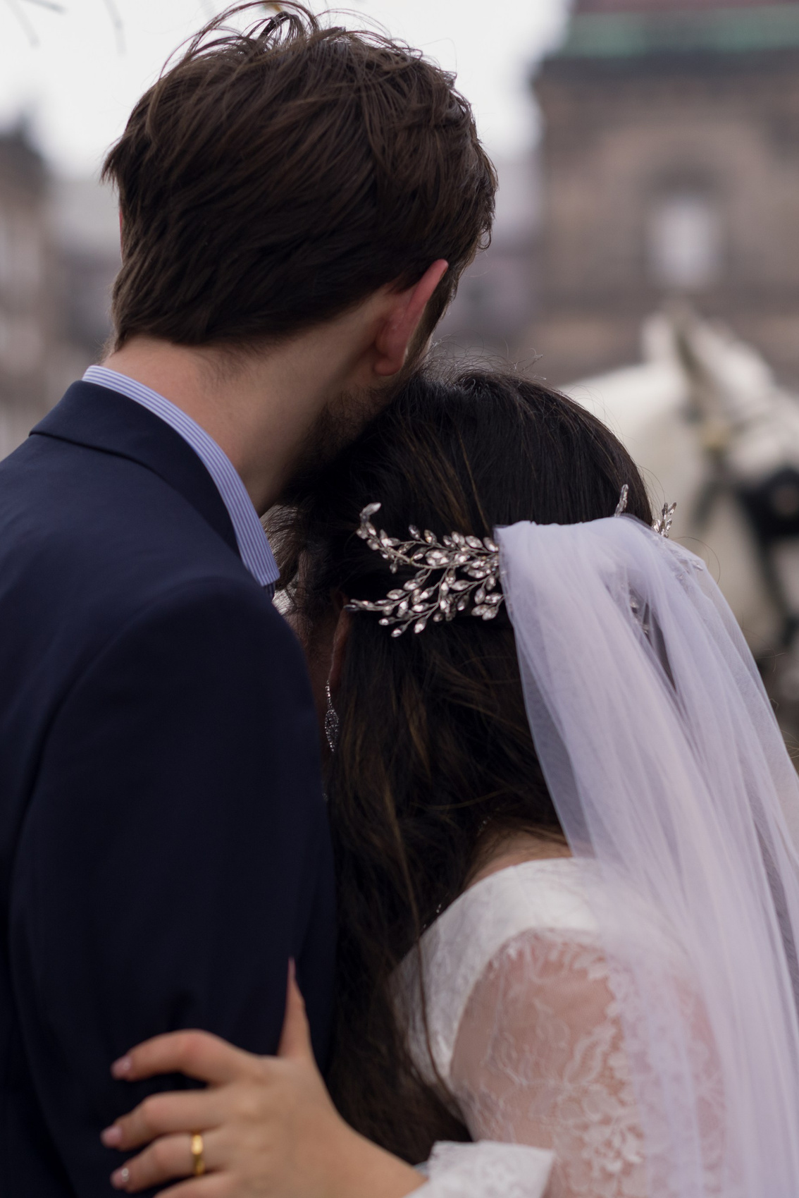 Tender hug between bride and groom and horses in Copenhagen