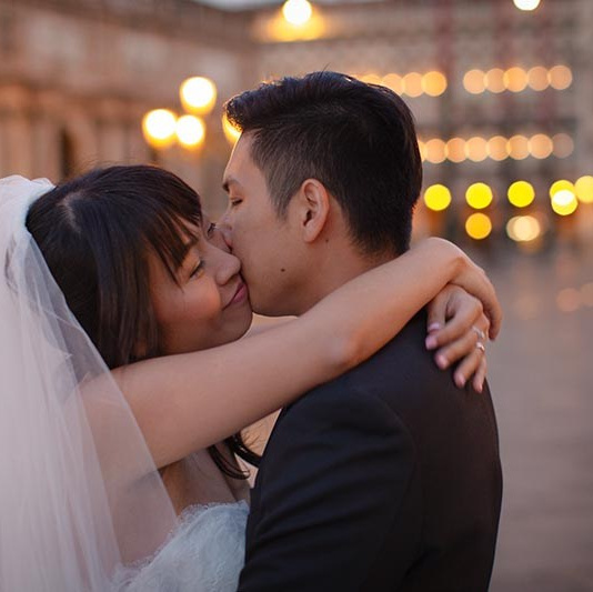 Newlyweds share an emotional embrace in St. Mark's Square at night in Venice - Kurt Vinion Photography