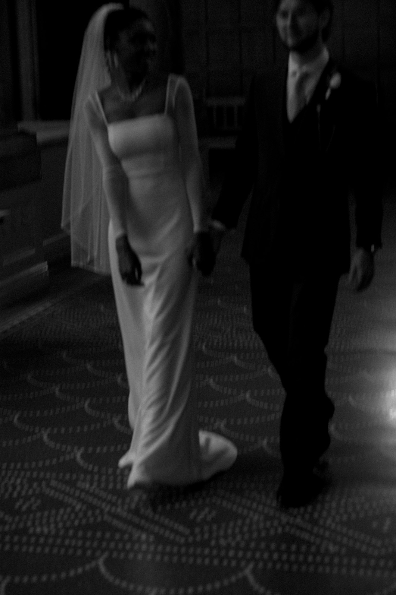 Bride and groom walking through Copenhagen City Hall.