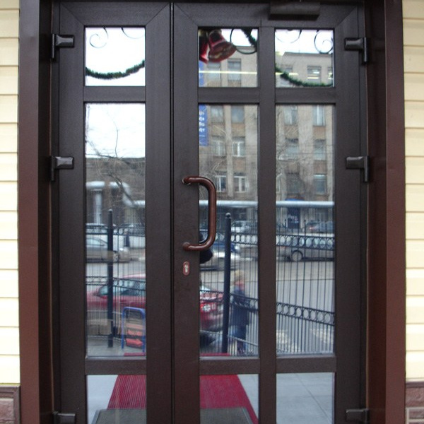 Металлопластиковая дверь входной группы в ламинации Темный Дуб с декором из горизонтальных и вертикальных импостов.