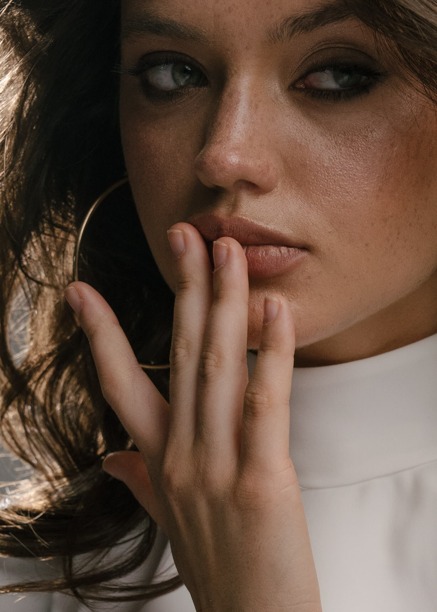 Close-up portrait of a woman with dark hair and soft makeup in natural light