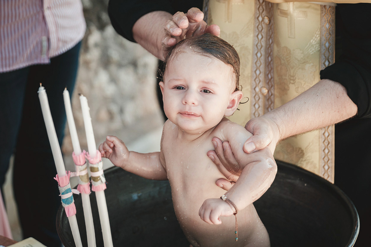 Малыш в купели во время таинства крещения на Крите. Фотограф, крещение детей в Греции.