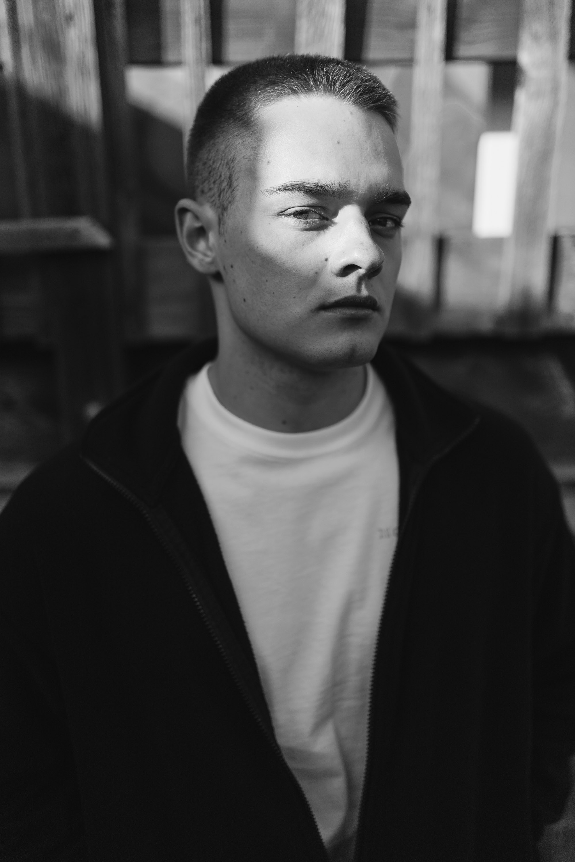 Black and white portrait of a man wearing sunglasses and a dark jacket