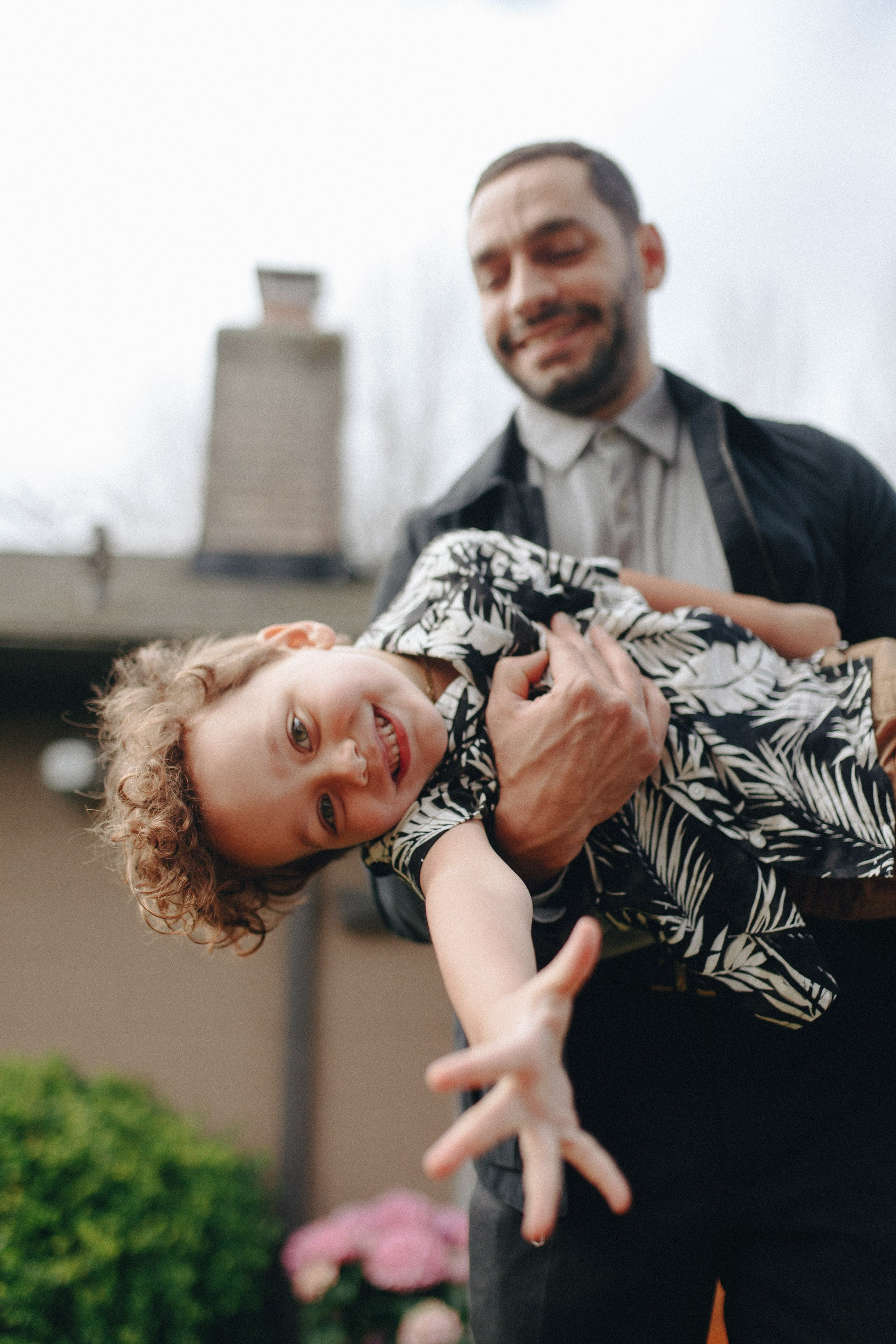 Couple holding baby, smiling near city skyline
