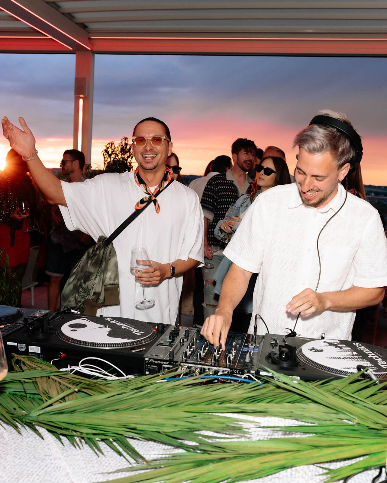 Sunset rooftop party with DJ and guests enjoying music