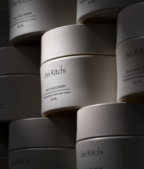 Minimal skincare containers stacked with shadow play — luxury packaging photography.