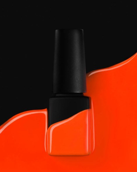 Black nail polish bottle with deep red gradient background — cinematic beauty product image.