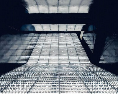 Пустая затемнённая комната с мигающим светом — минималистичная световая инсталляция, исследующая восприятие времени и пространства.