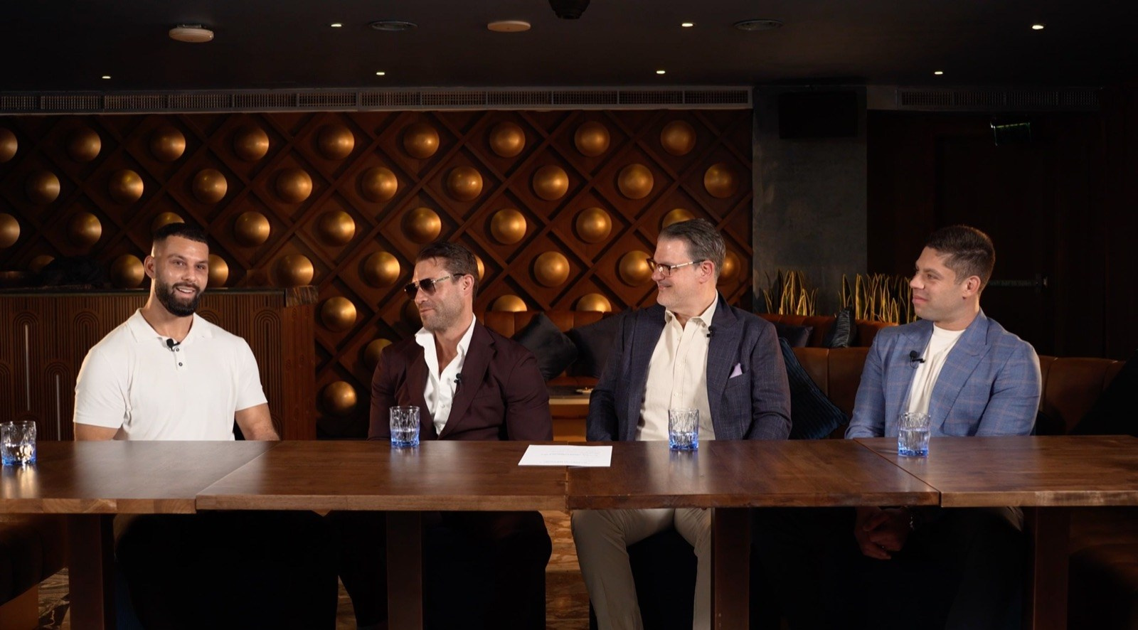 Four business speakers taking part in an on-location video podcast discussion