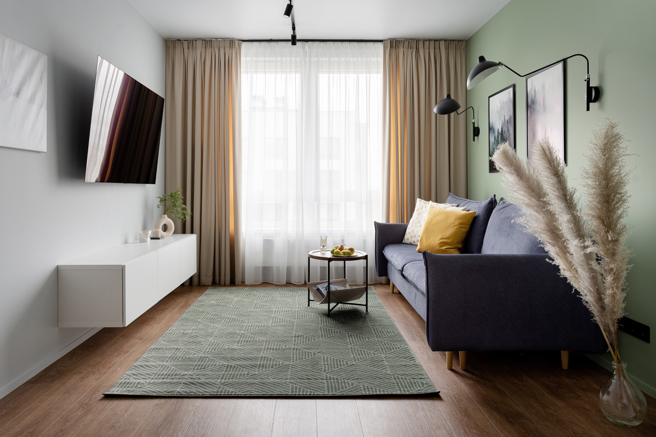 Уютная гостиная со светлым диваном и столом.