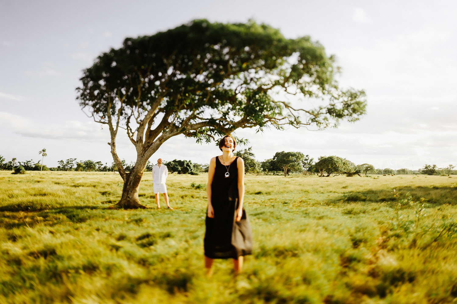 Chris stands in a black dress and smiles at the photographer.