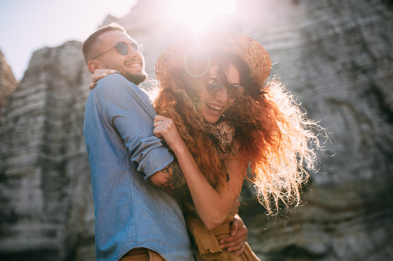 The newlyweds smile at each other, the bride has red curly hair, and the groom has a blue shirt.
