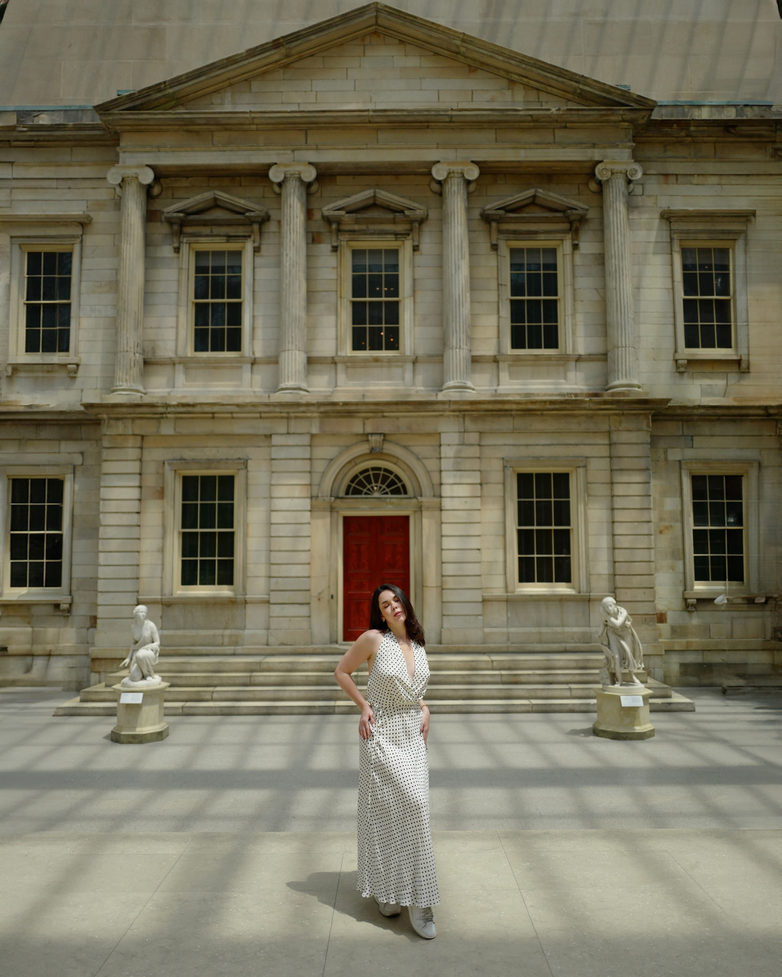 a woman standing in front of a large building