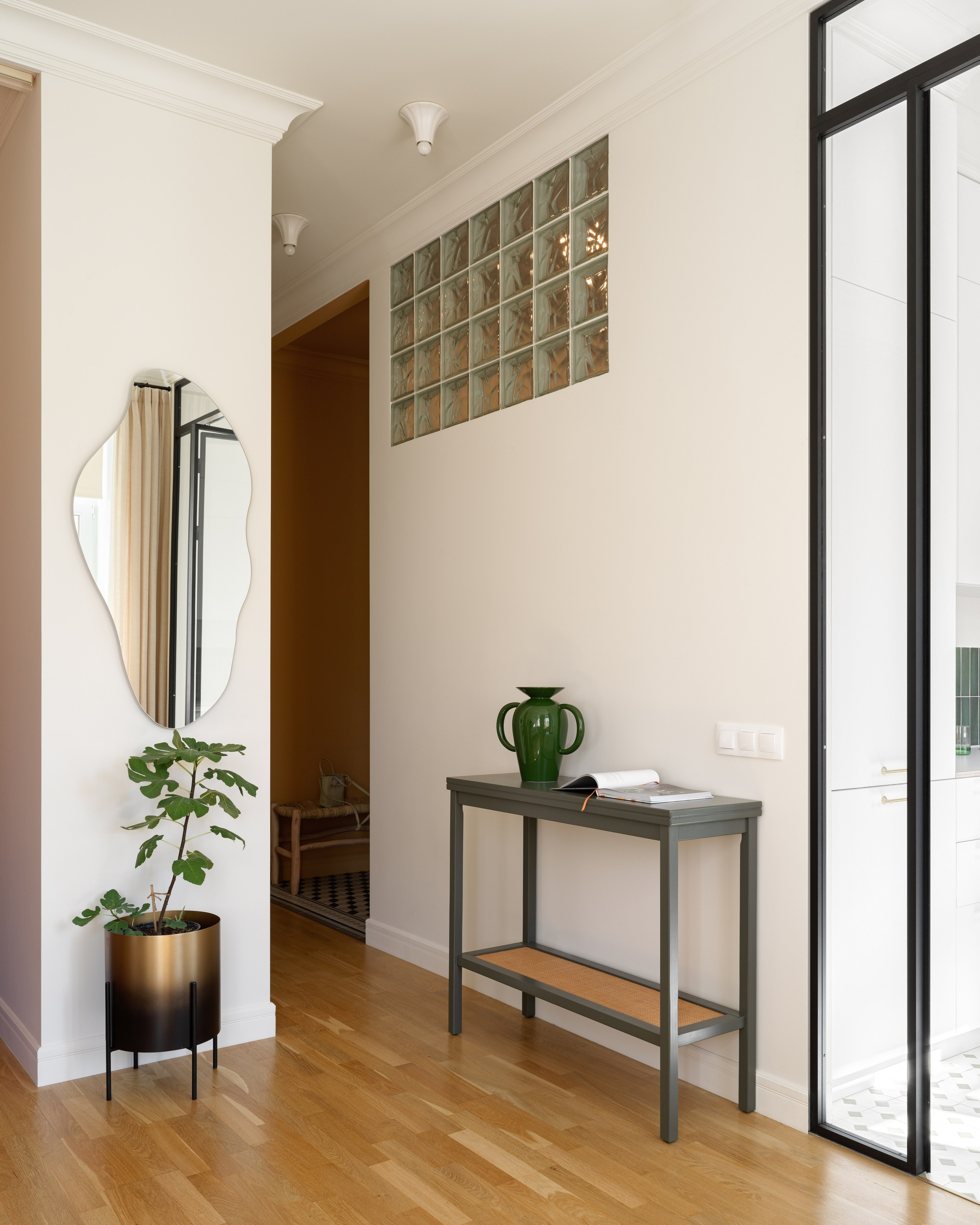 Интерьер с высоким потолком, арочными окнами и световым окном из стеклоблоков.