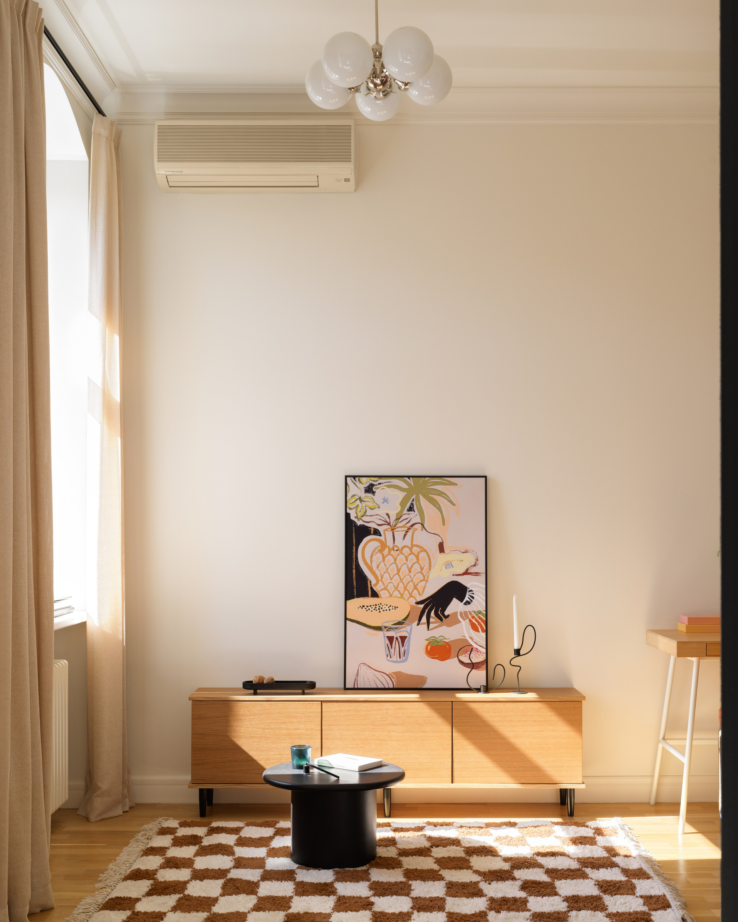 ТВ-зона с тумбой из шпона, ковром в шахматный узор и винтажной люстрой.