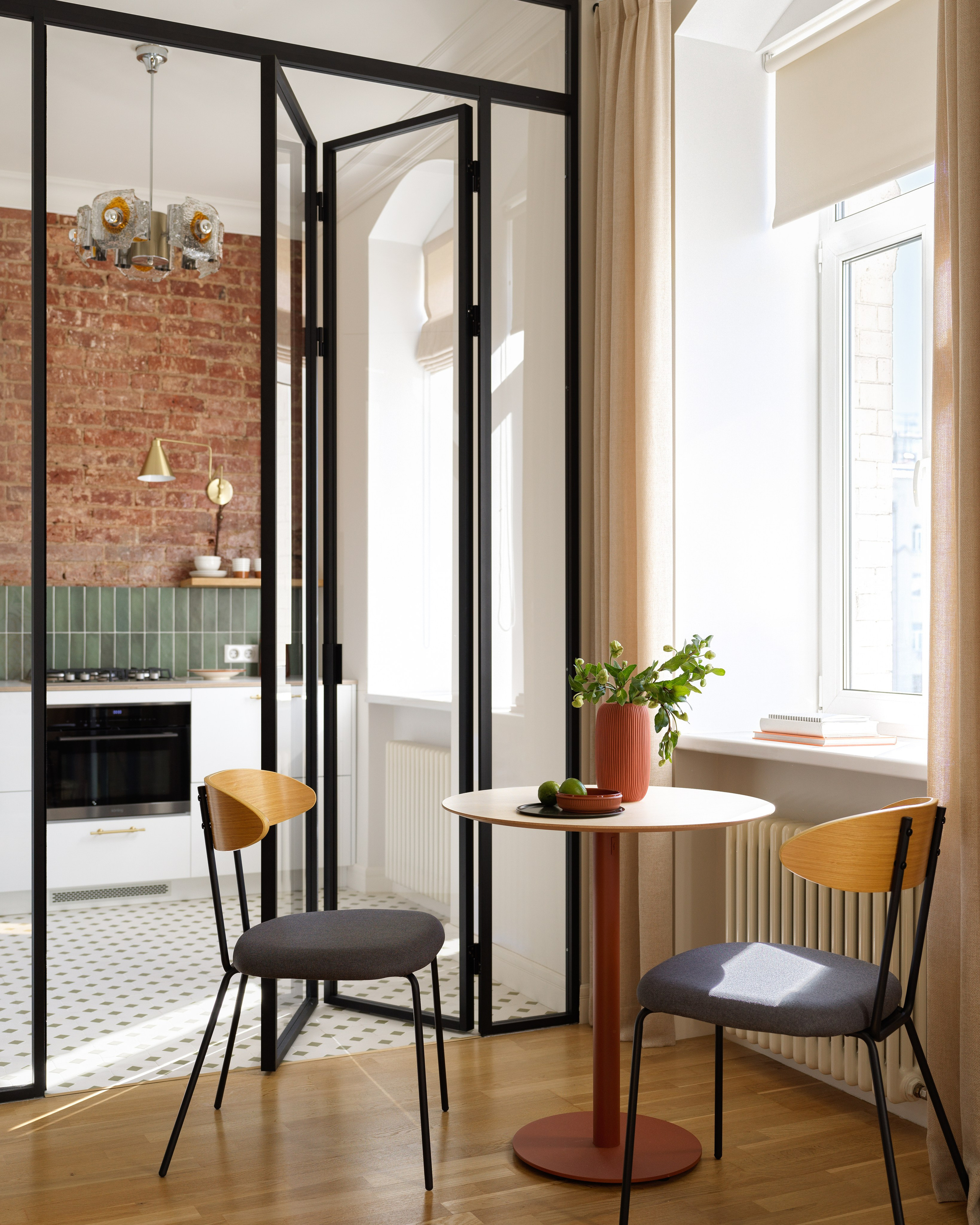 Стеклянная перегородка гармошка в черном профиле для зонирования кухни и гостиной.