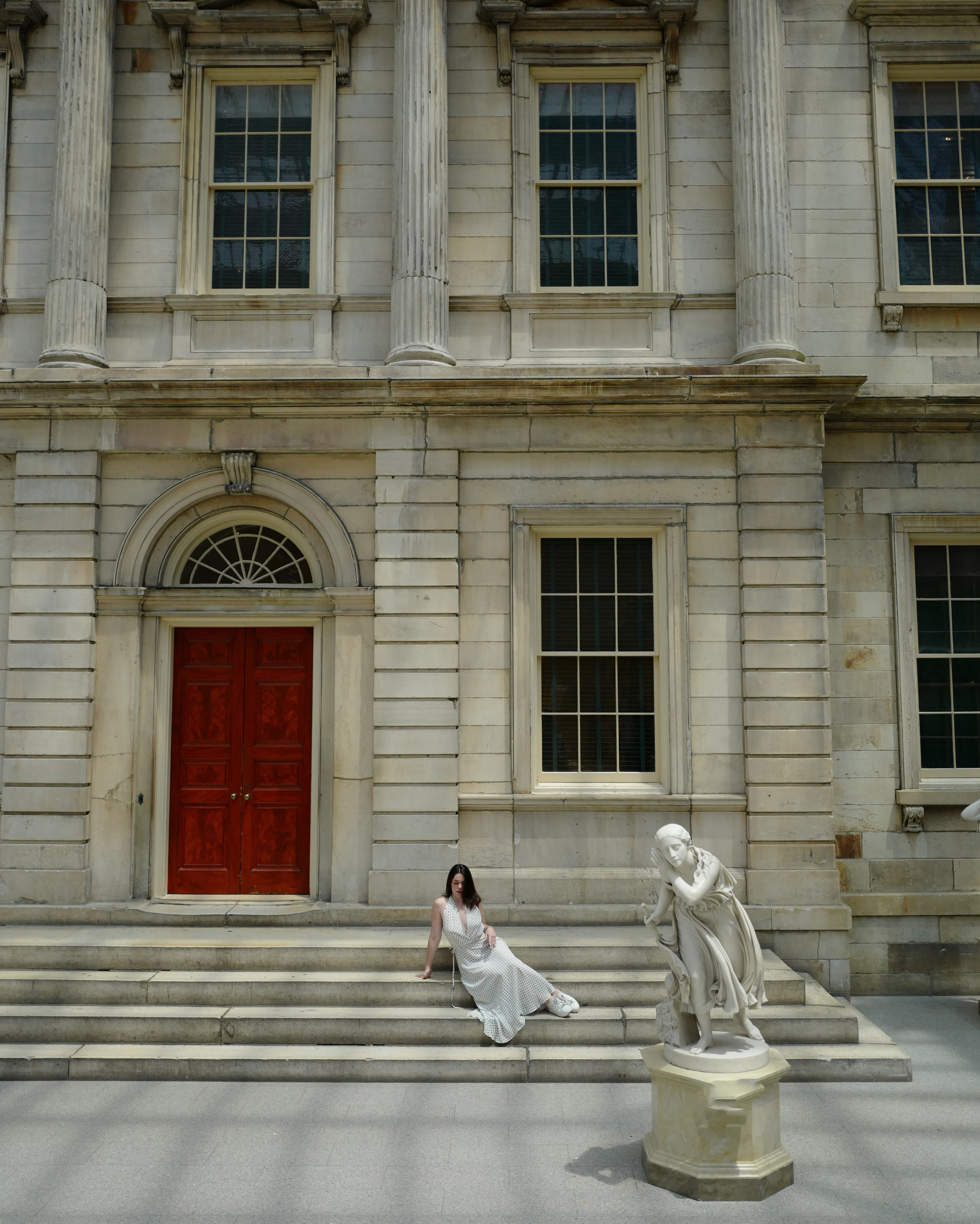 a woman sitting on the steps of a building