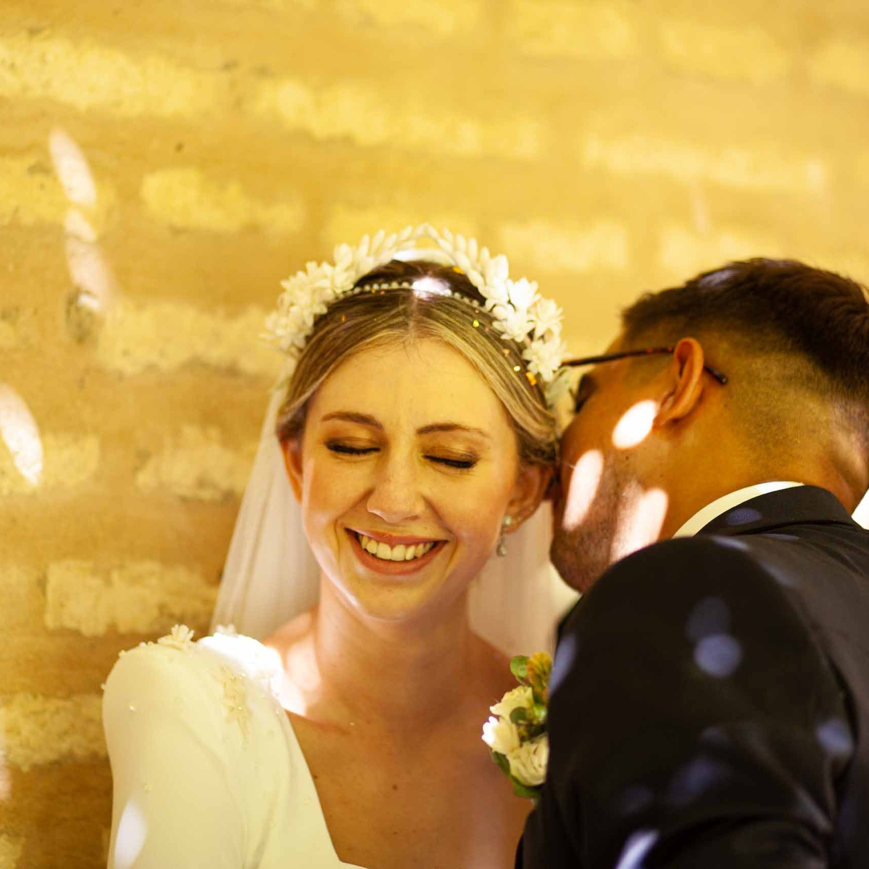 Pareja de novios, el novio le dice algo al oido a la novia y esta se ríe