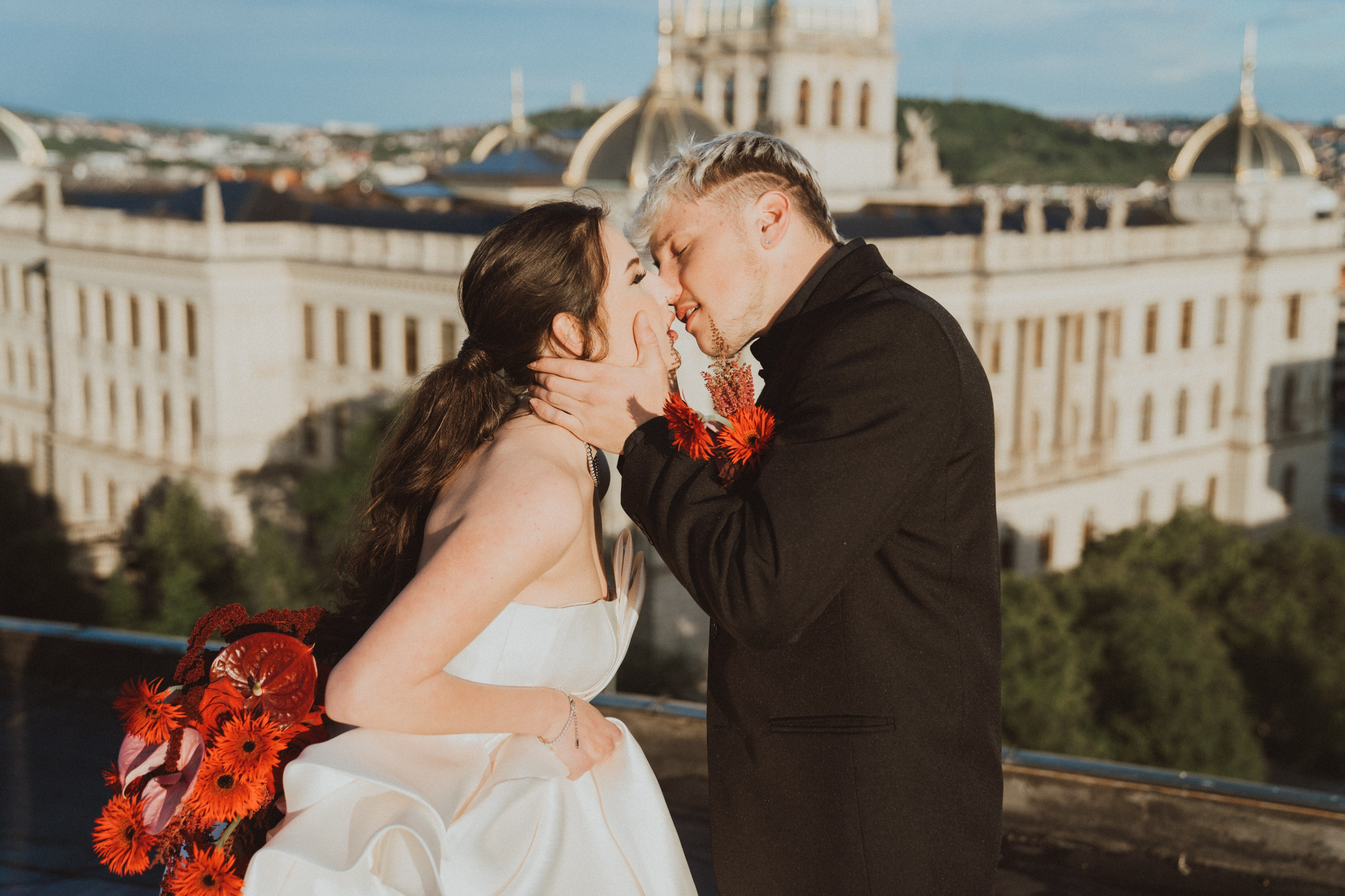 Svatba ve dvou v Praze, polibek novomanželů na střeše s výhledem na město.