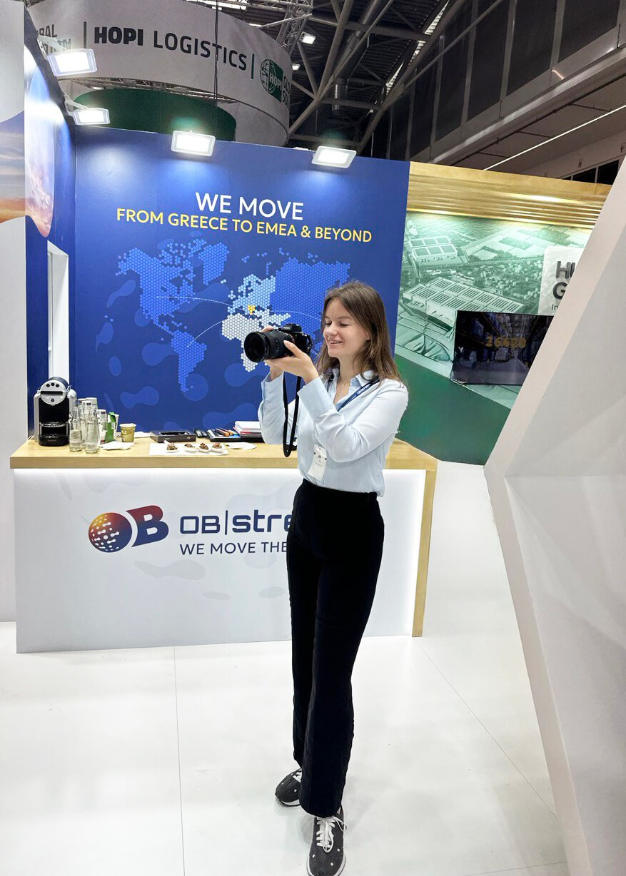 Inna Zaytseva, professional photographer, taking event photos at a trade show booth during a business exhibition