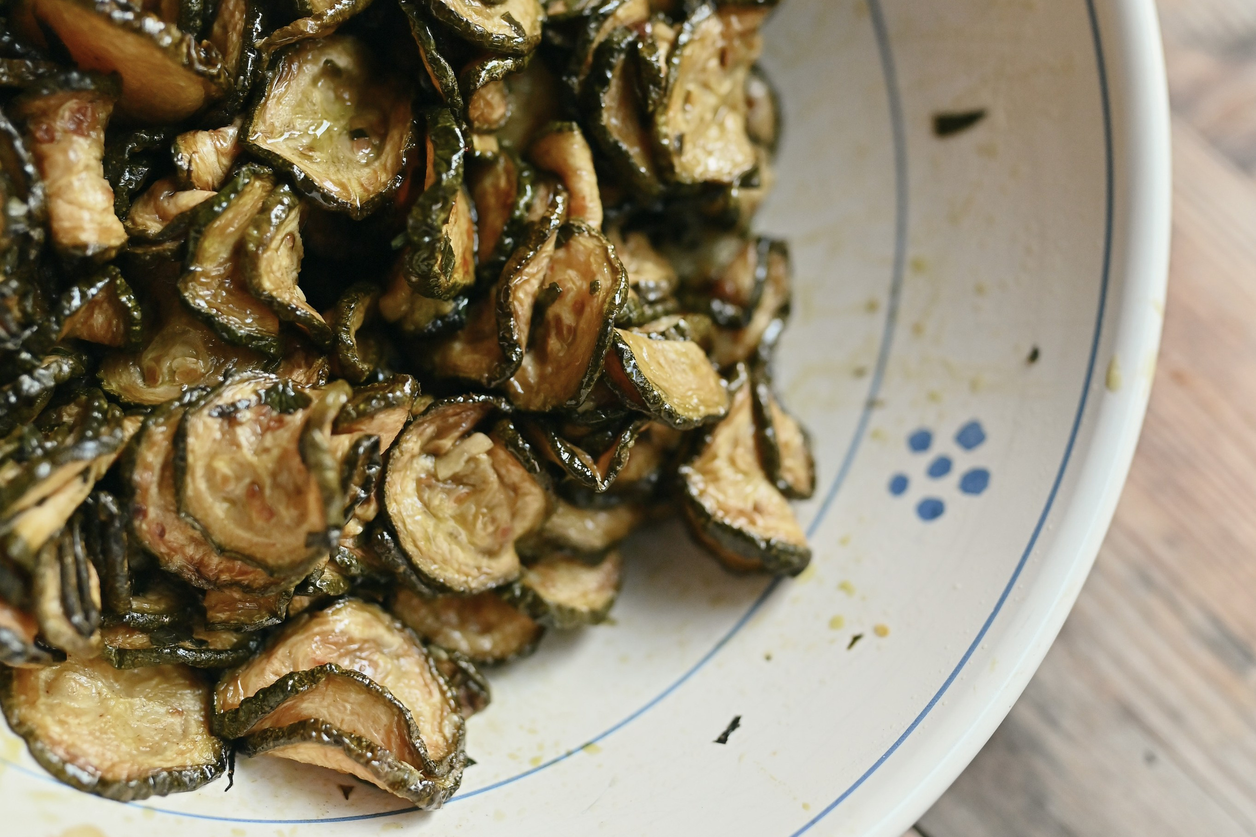 Apulian-style fried zucchini with olive oil, garlic, and mint, served in a ceramic bowl.