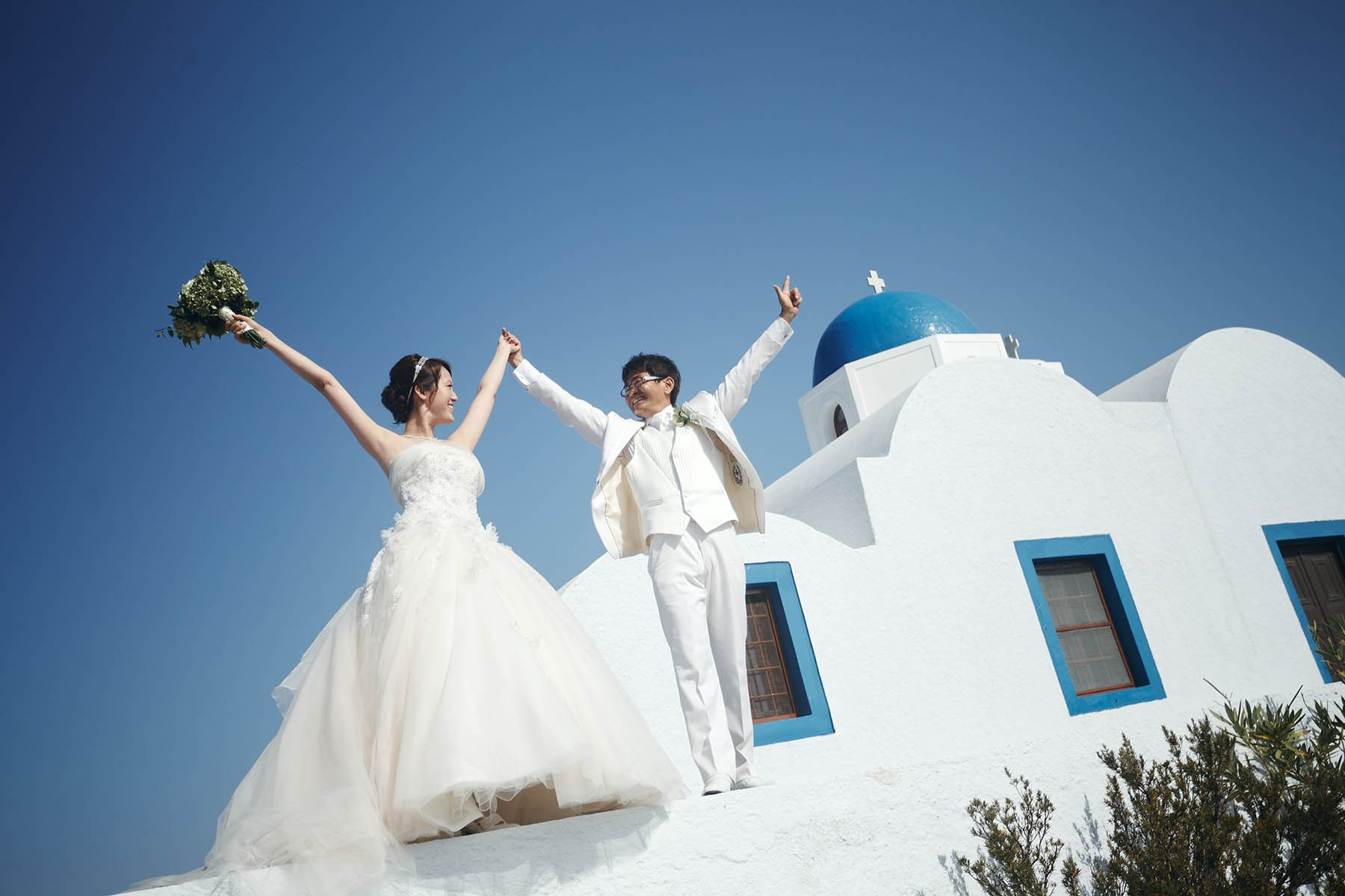 Nao and Junji celebrate by ringing the Three Bells of Fira in Santorini.