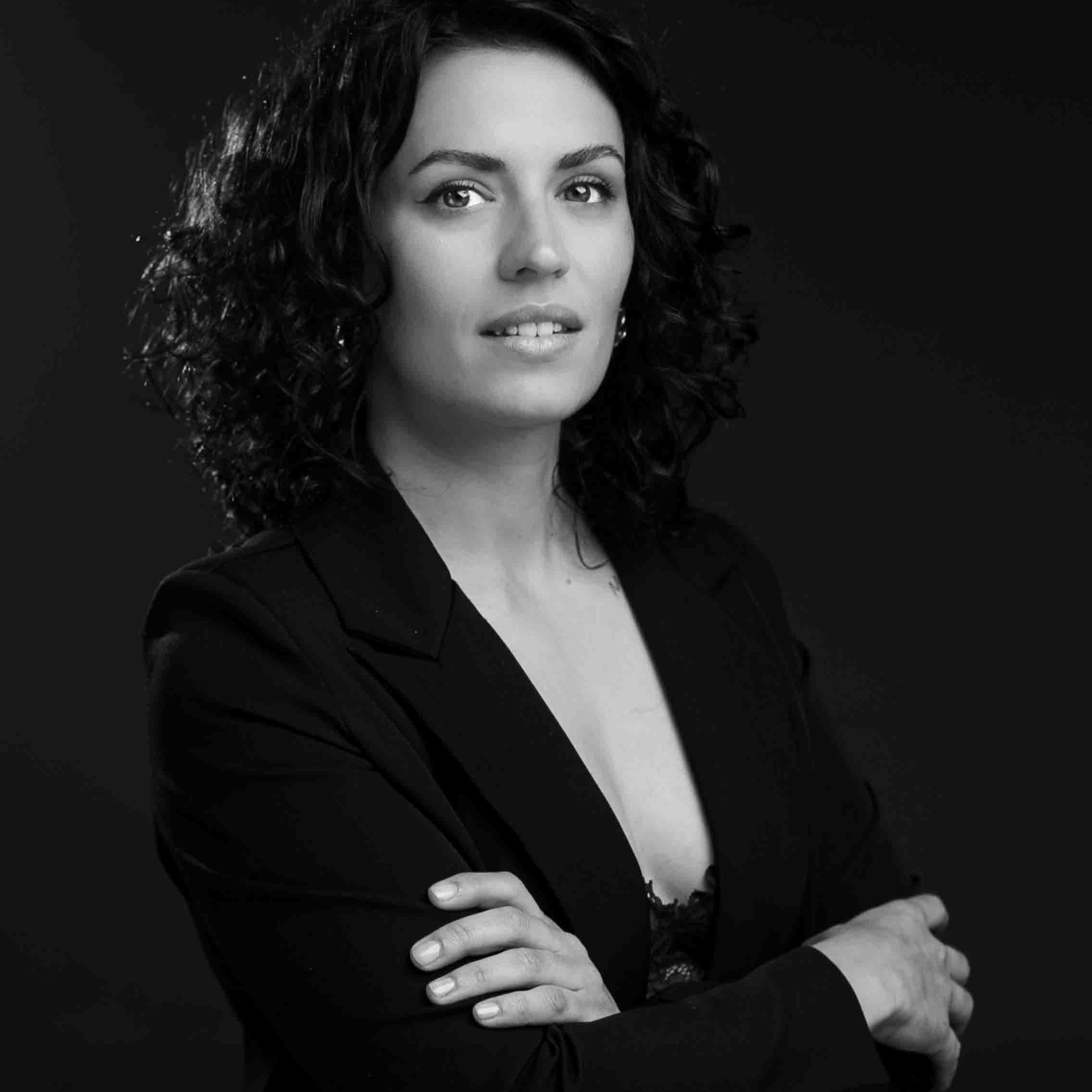 Ejecutiva con chaqueta negra y brazos cruzados al frente