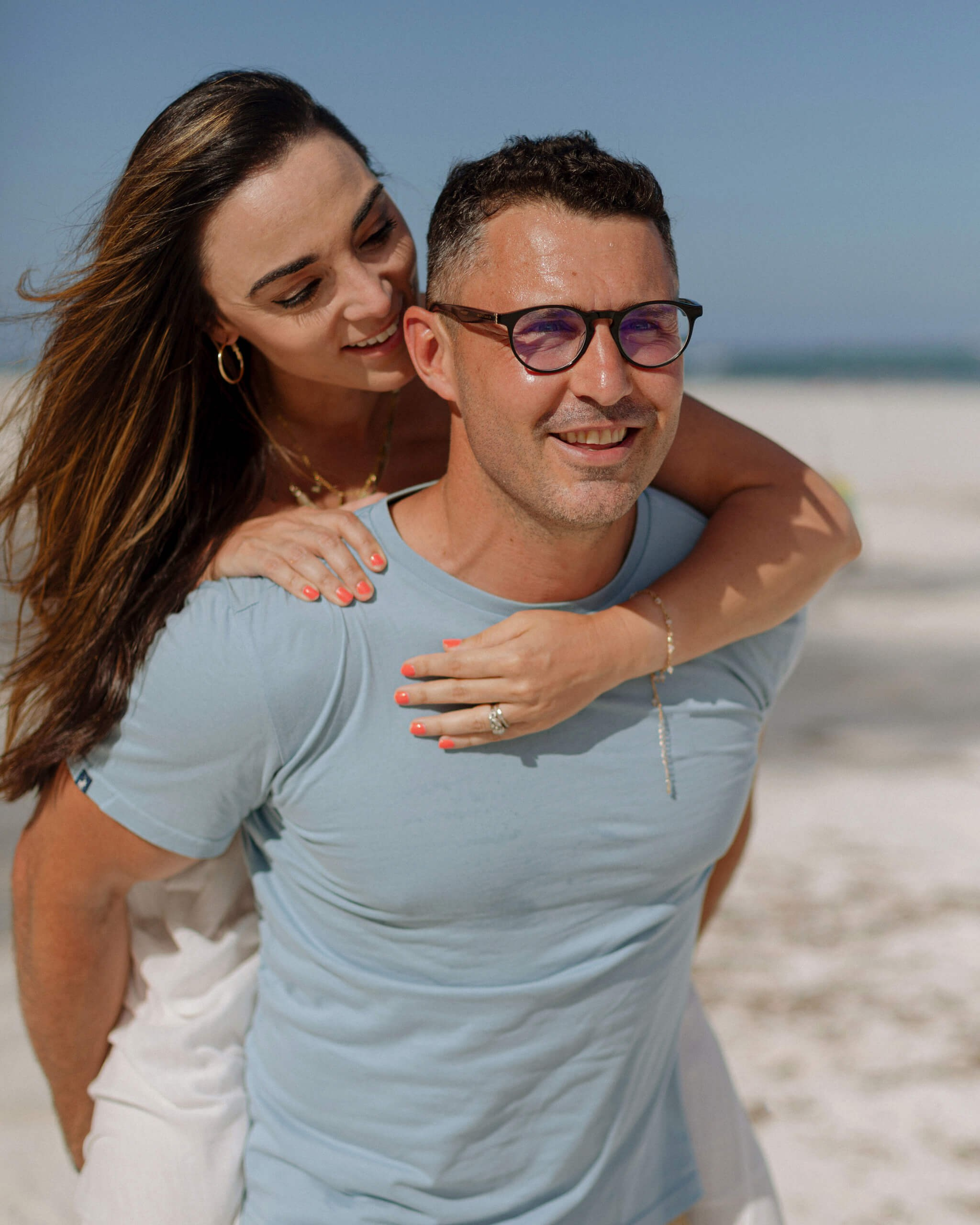 Watamu coastal photography, joyful couple piggyback on the beach.
