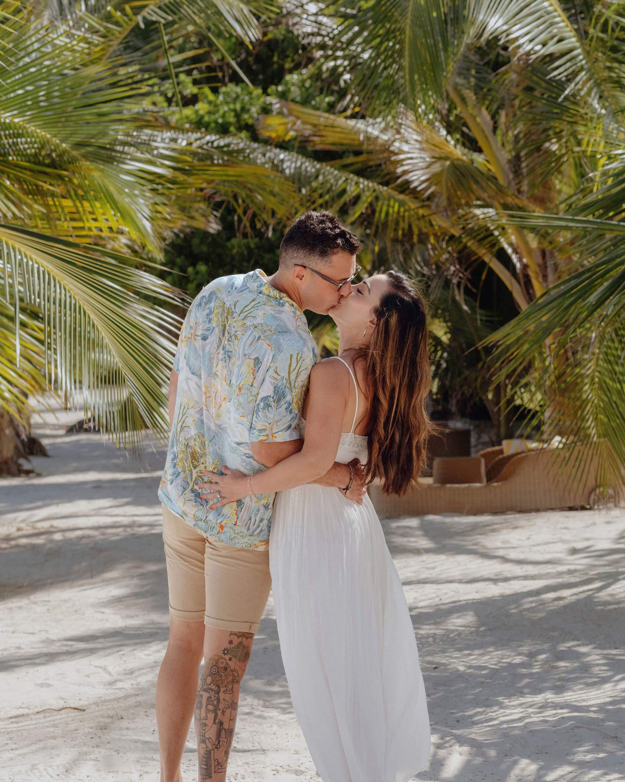 Diani Beach pre-wedding shoot, couple gazing under palm tree shade.