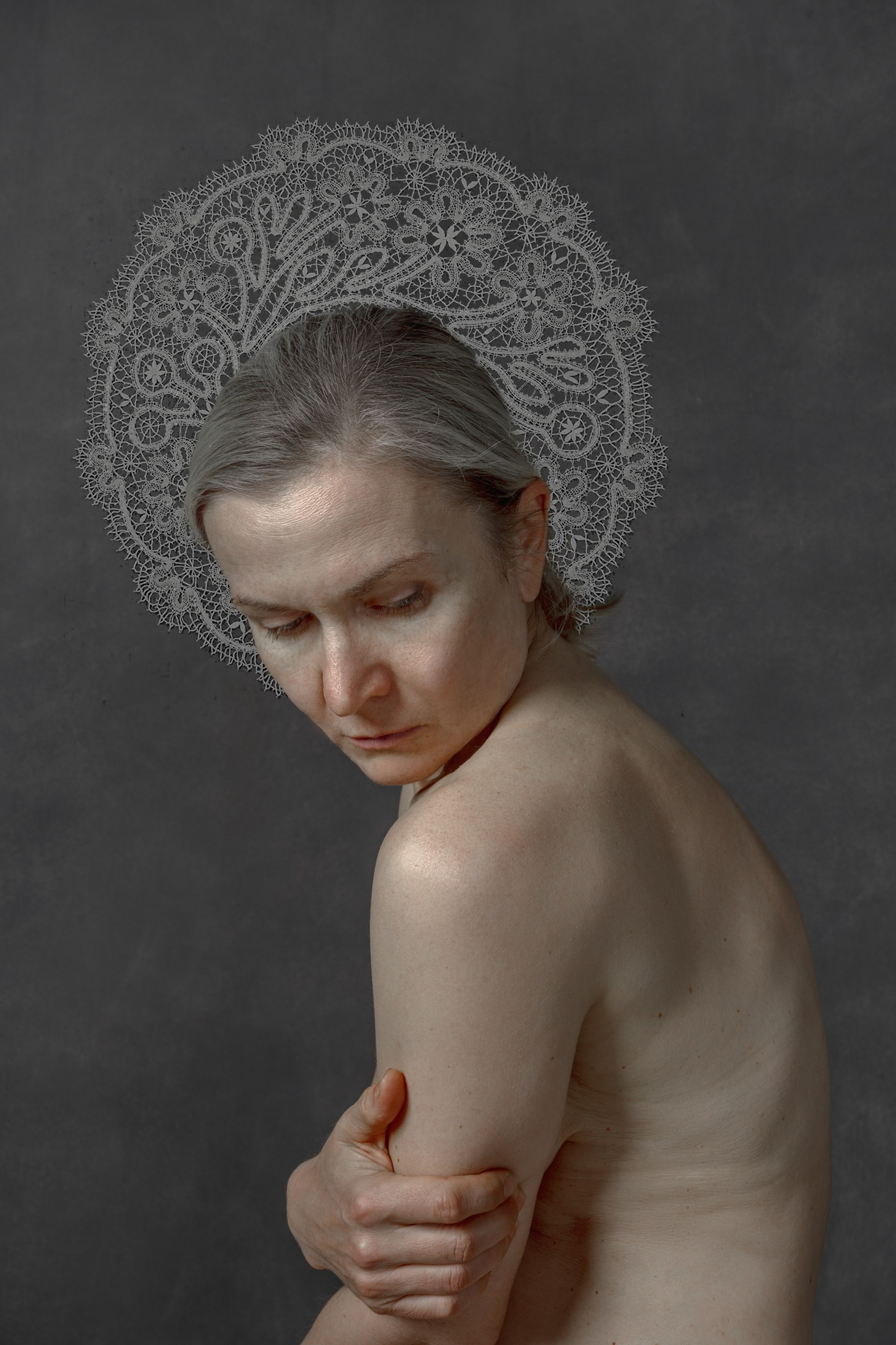 Portrait of a contemplative woman with a lace halo, symbolizing sacred femininity, memory, and ancestral connection – fine art photography by Maria Tulchinskaya.