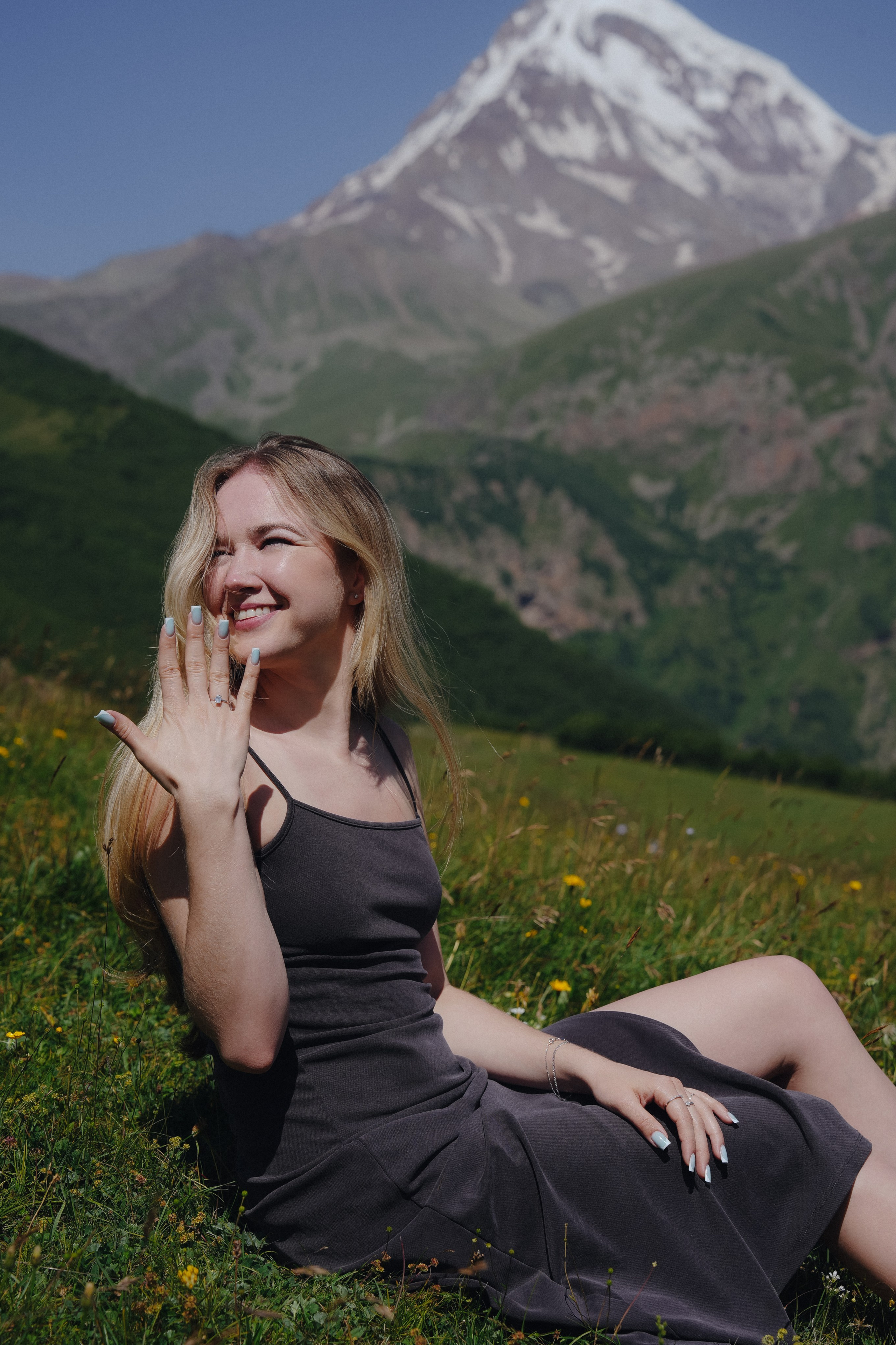Bride-to-be is showing off her ring during the surprisal proposal un Kazbegi mountains.