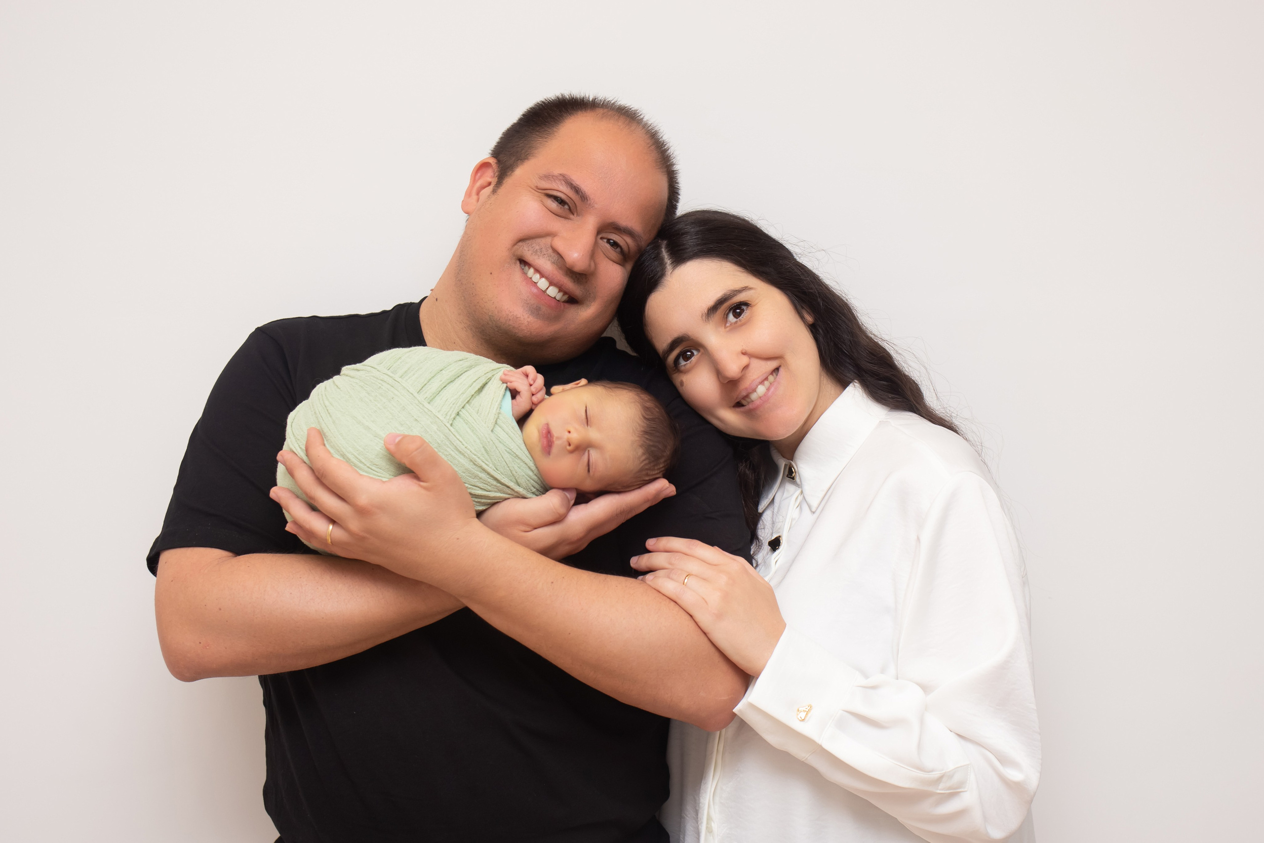 Parents cuddling their newborn baby