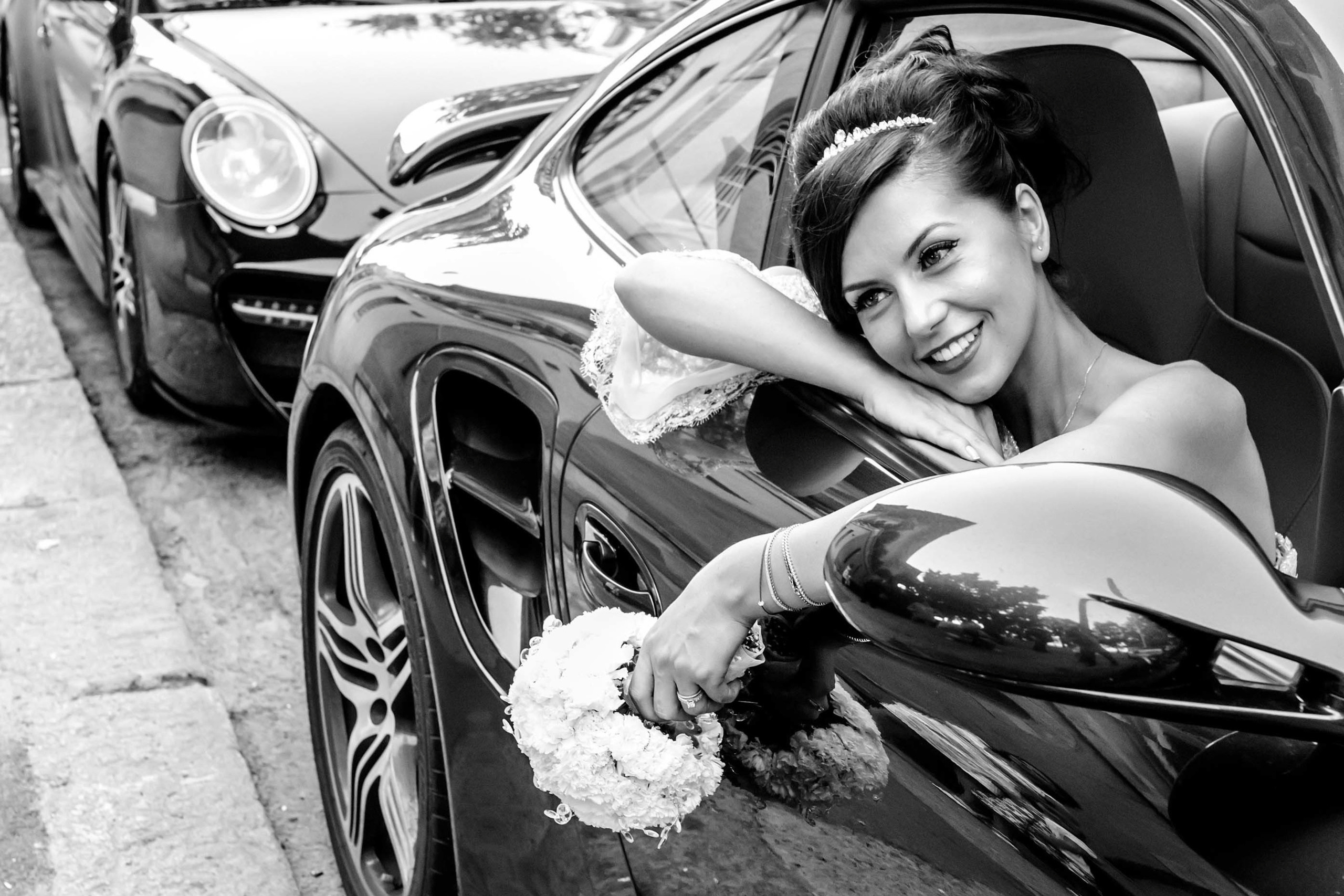 Wedding photographer Kupolla Events Mamaia, Romania  Smiling bride holding bouquet staying in Porsche Nikon D850