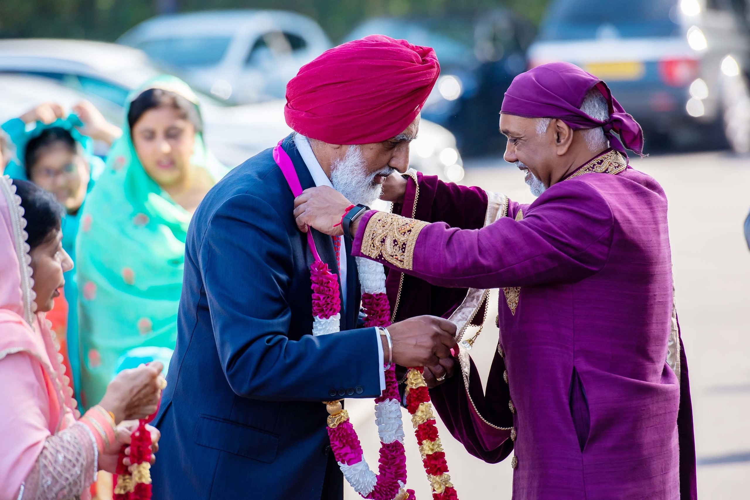 Wedding photographer Guru Nanak Darbar Gurdwara London UK Nikon D850 Relatives exchanging flower garlands on asian wedding