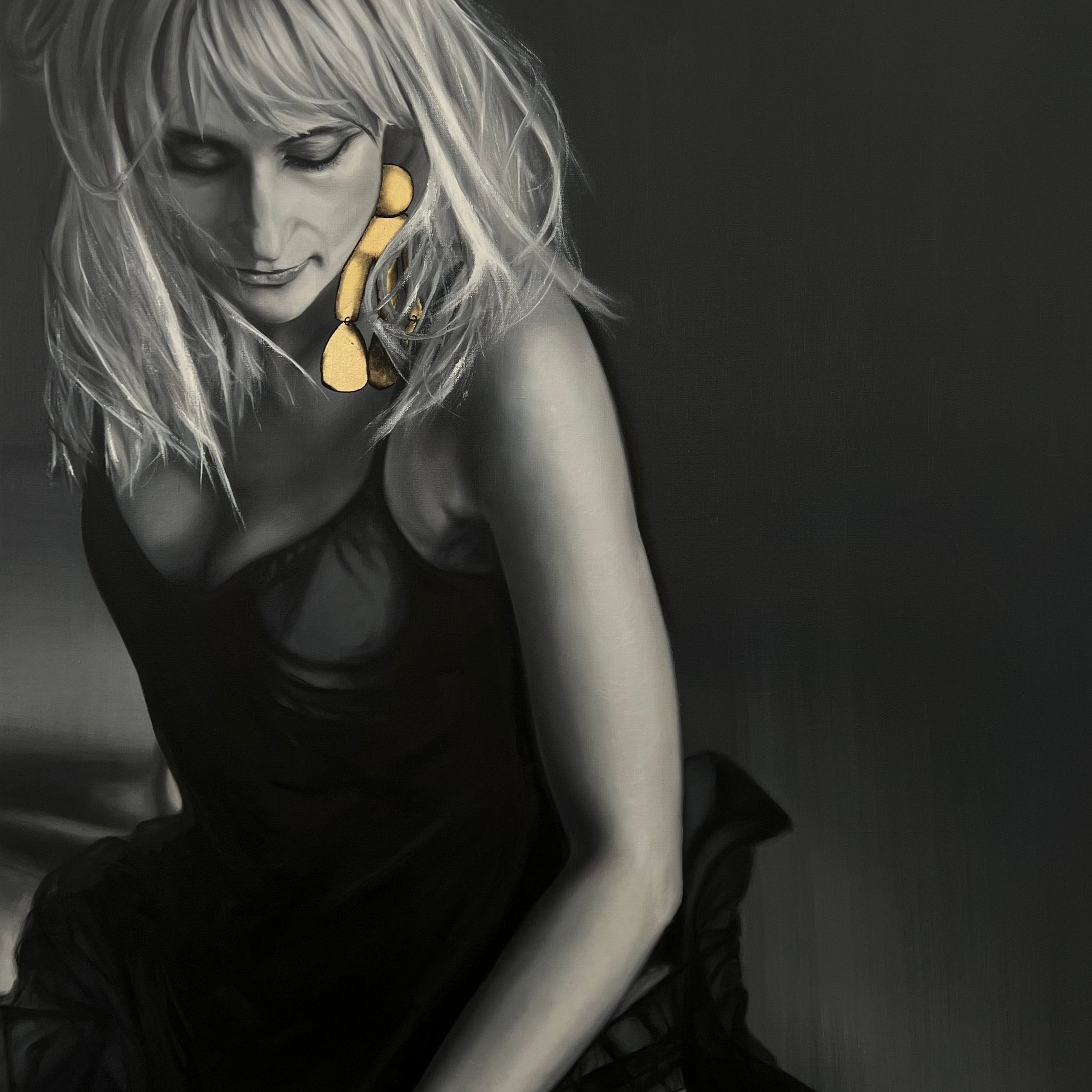 Женщина блондинка с золотой серьгой на чёрном фоне