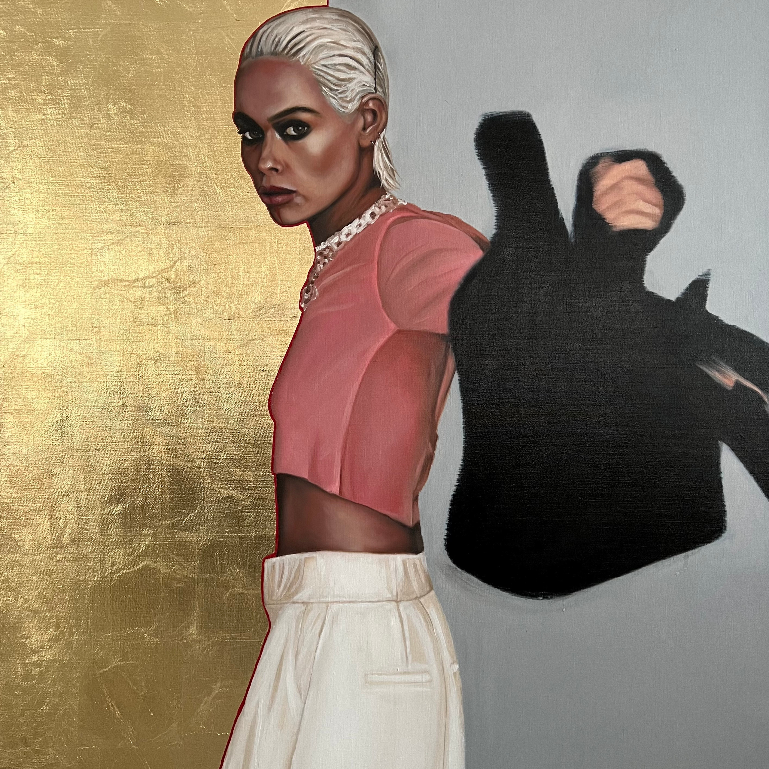 Дерзкий взгляд блондинки в чёрном пиджаке с тенью на золотой стене