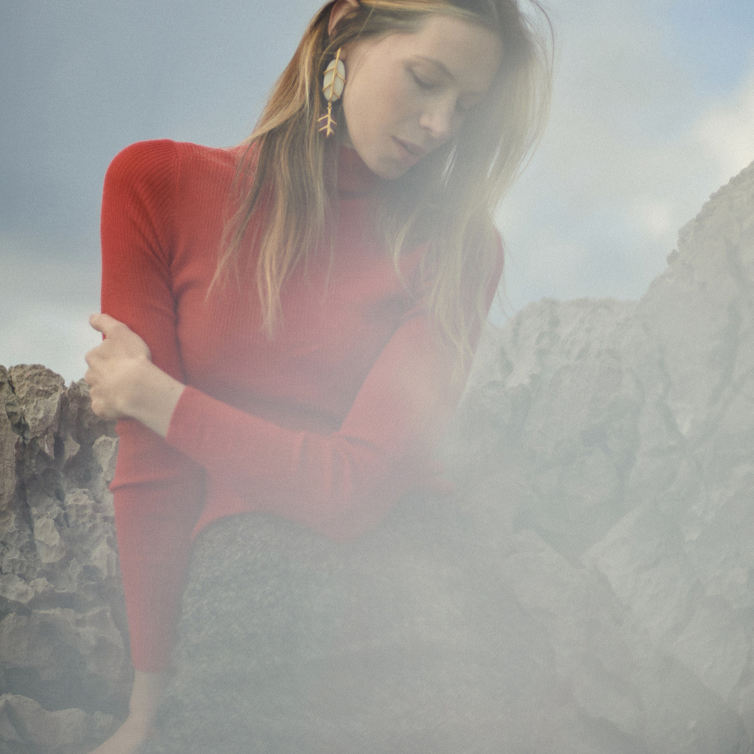 Artistic blurred and mysterious portrait of a woman in a red long sleeve, creative fashion photography