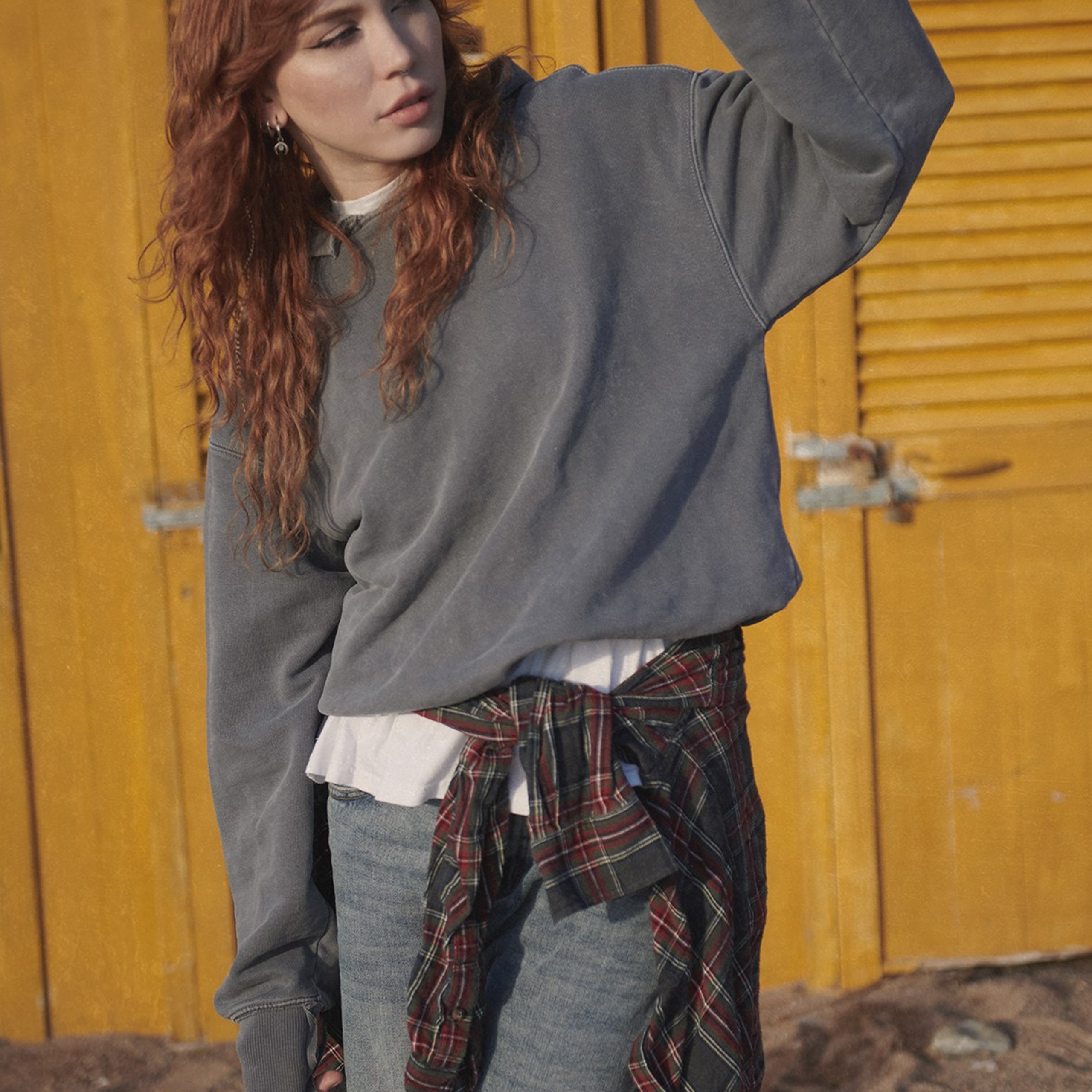 Artistic outdoor photoshoot with a red haired model wearing denim, captured in natural light