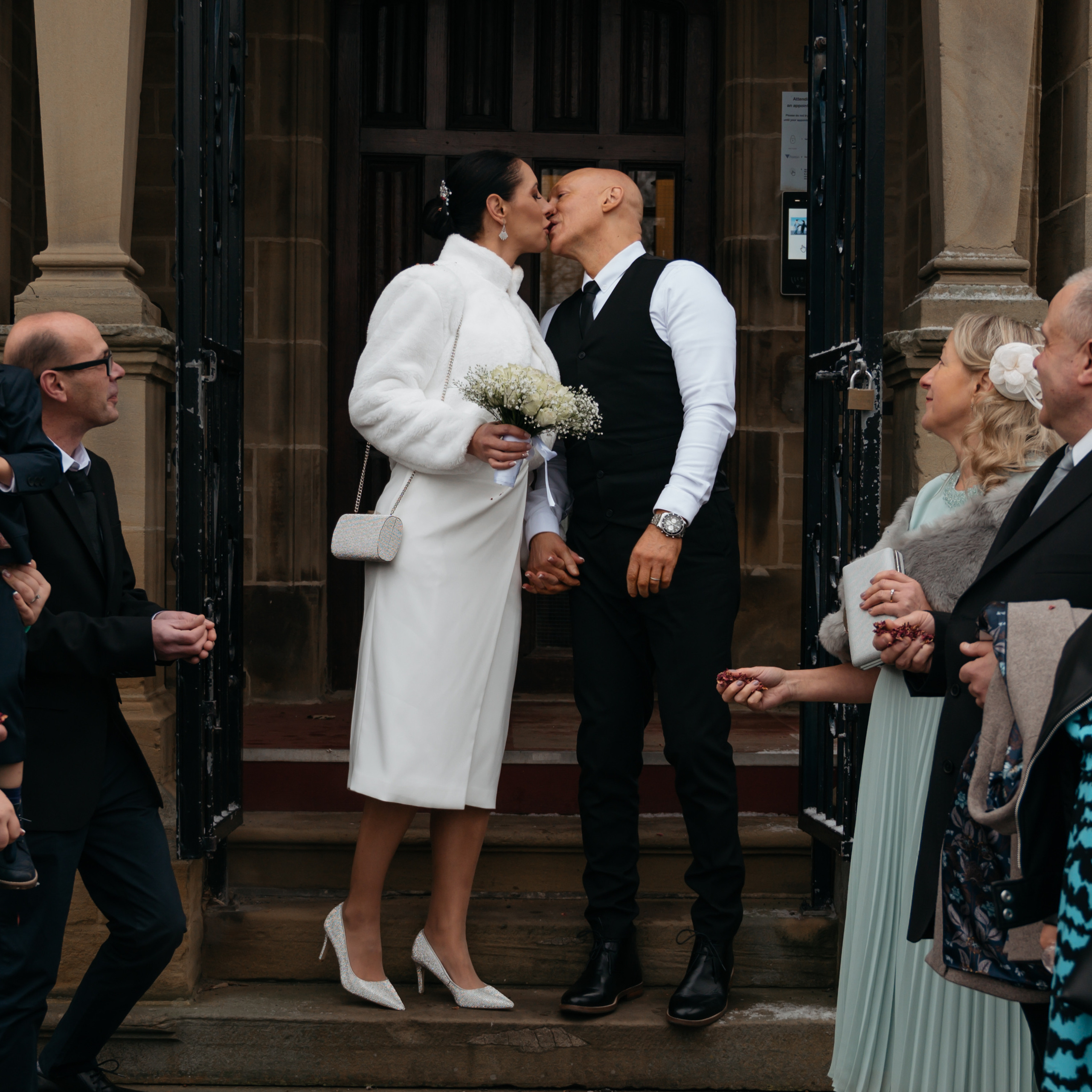 Bride and groom having confetti shot in front of Halifax registry office.