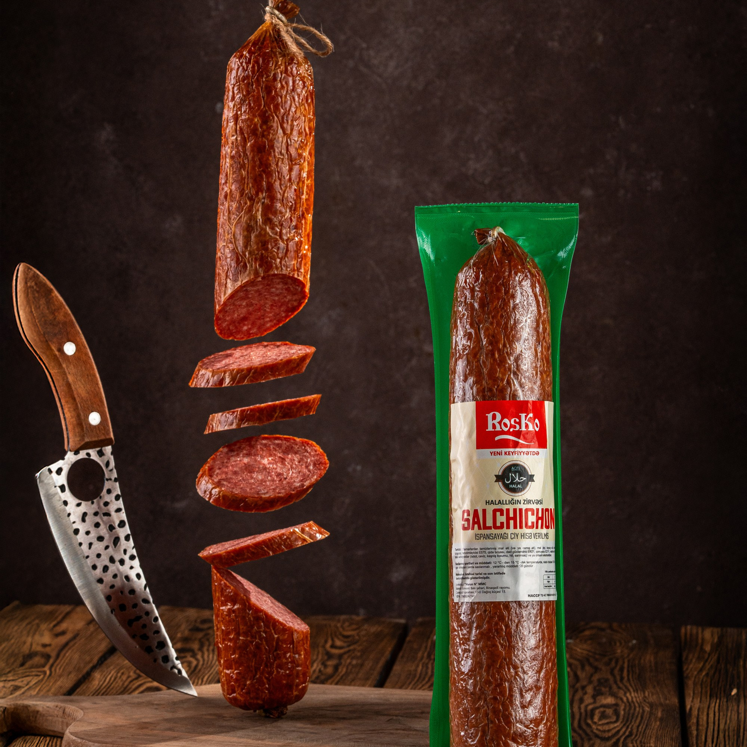 Roska “Salchichon” kolbasası, havada kəsilmiş hissələri və kəsici bıçaqla yaradıcı, dramatik qida fotoqrafiyası nümunəsi.