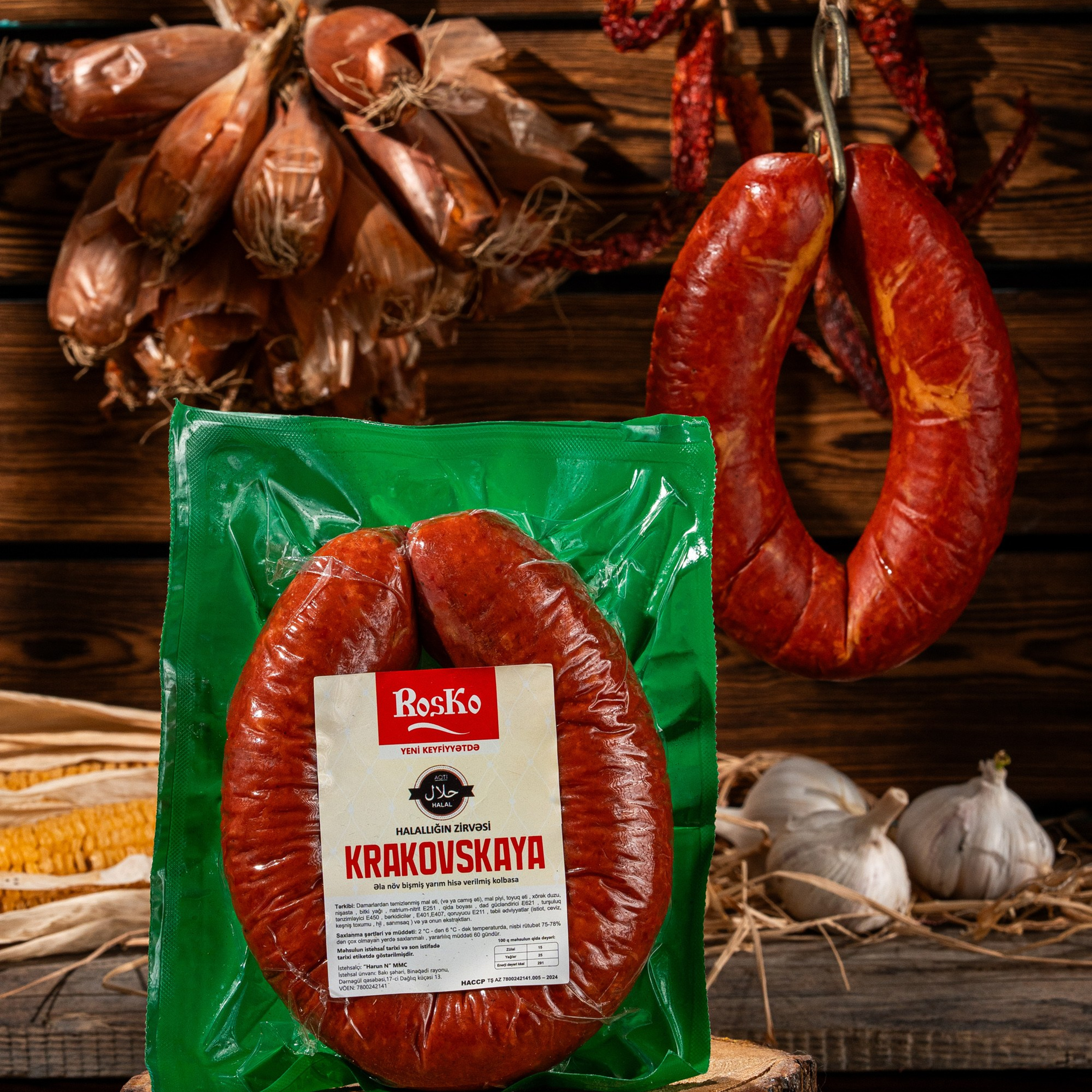 Roska “Krakovskaya” sausage presented in a rustic setup with wooden background and hanging dried spices.