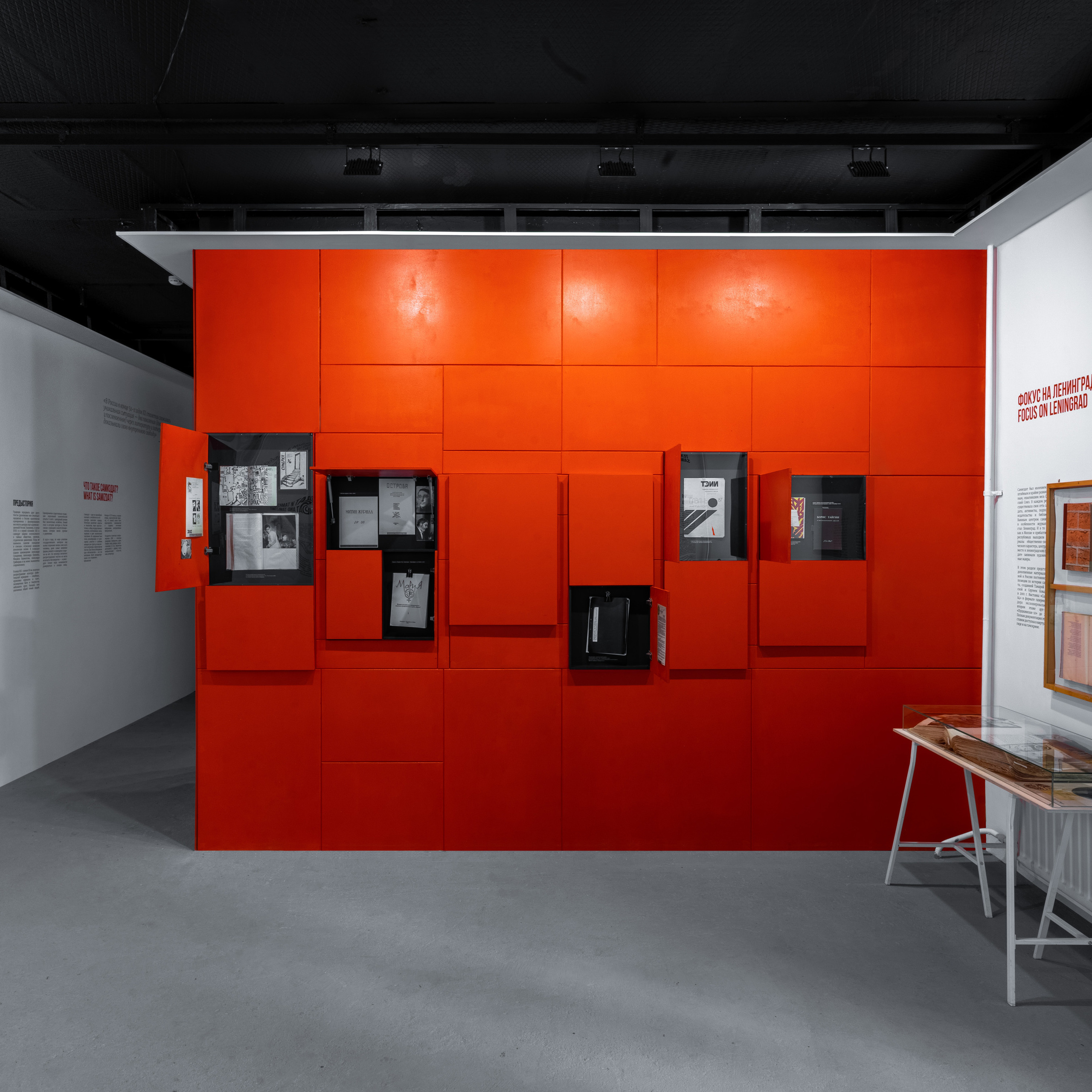 Contemporary exhibition space with a striking red modular display, utilizing a neutral color balance to contrast with the vibrant panels, likely shot with a standard zoom lens for versatile composition