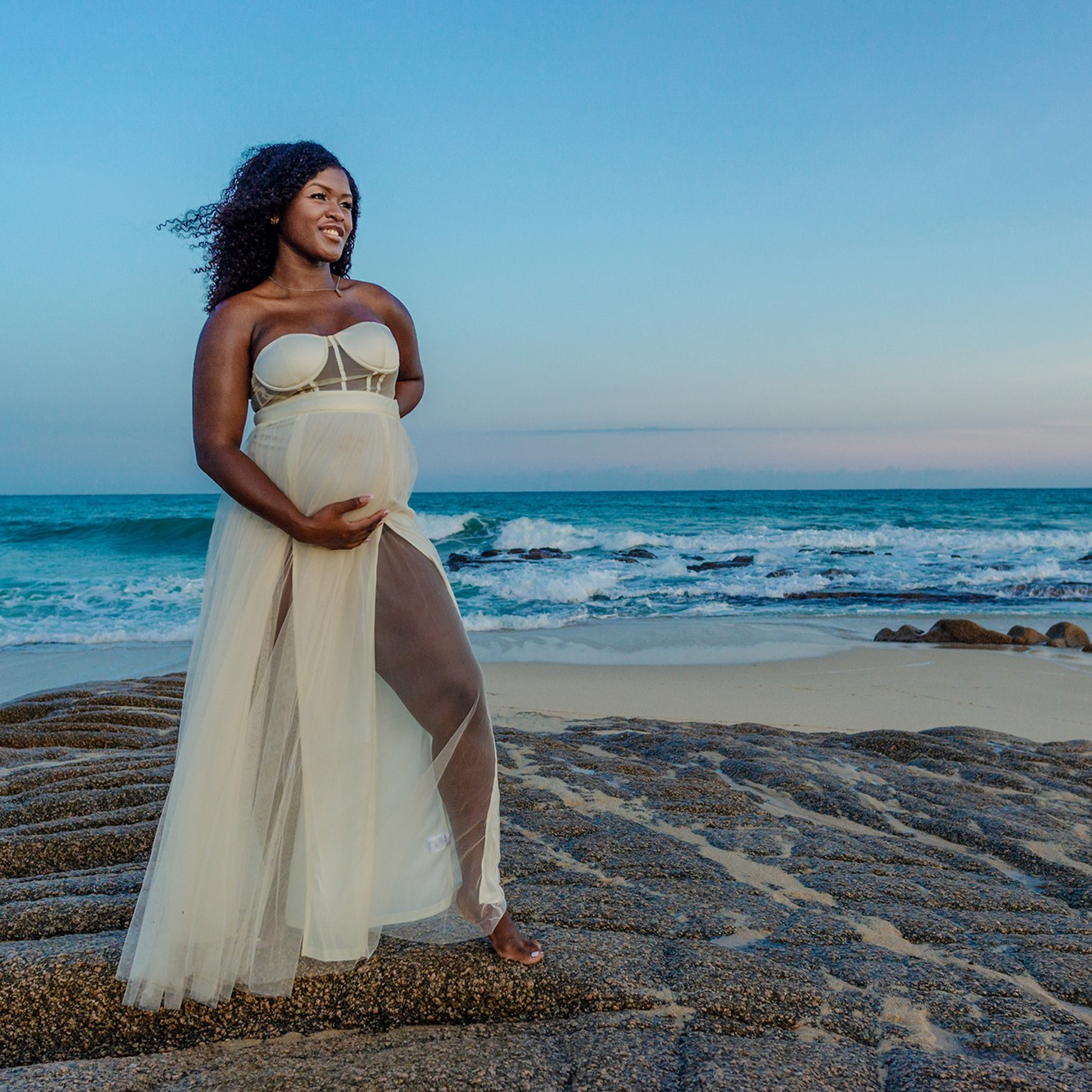 Expecting mother portrait in Los Cabos – glowing maternity session with soft light, ocean waves, and desert coastline, symbolizing the beauty of waiting for new life.