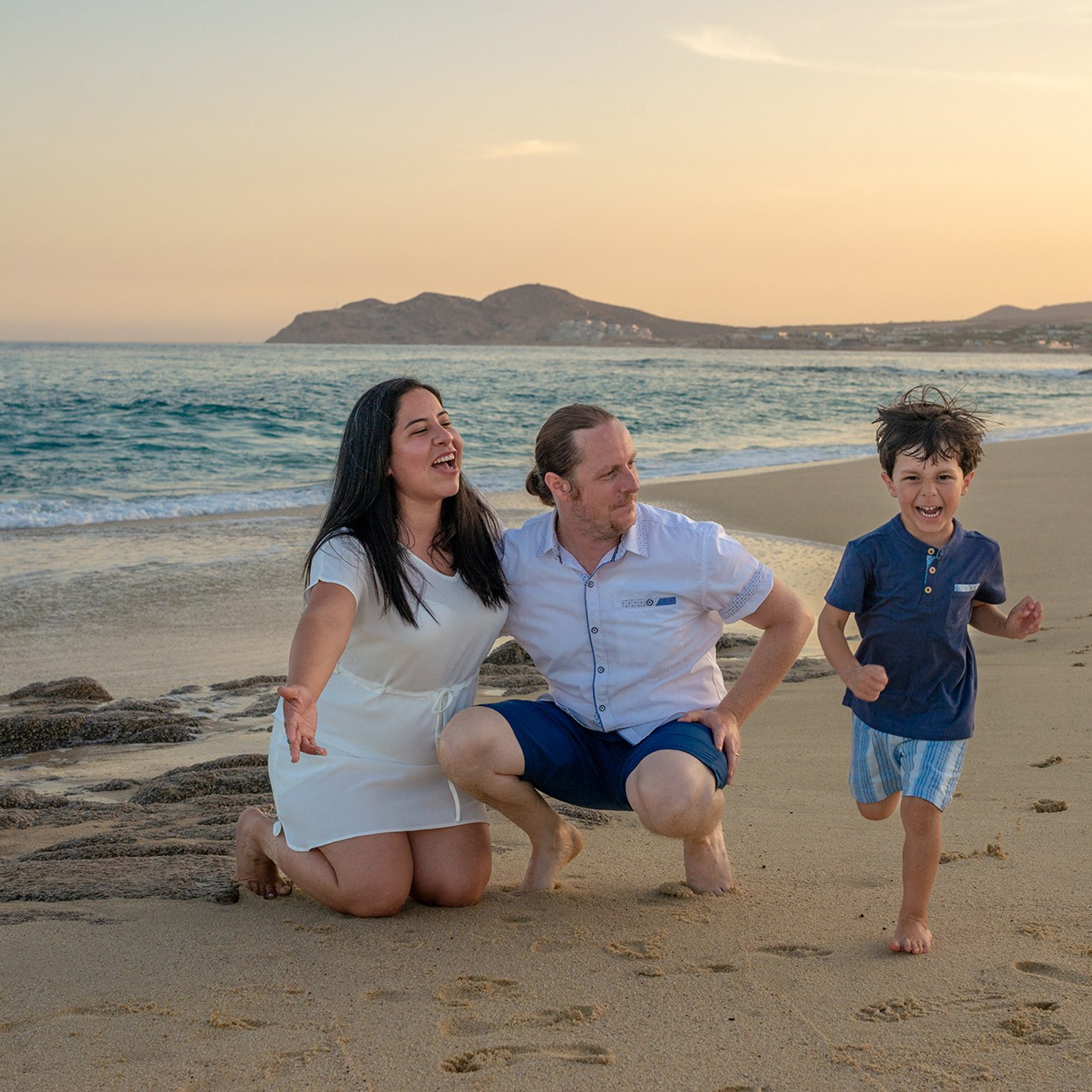 Parents playing with their toddler on Los Cabos beach.