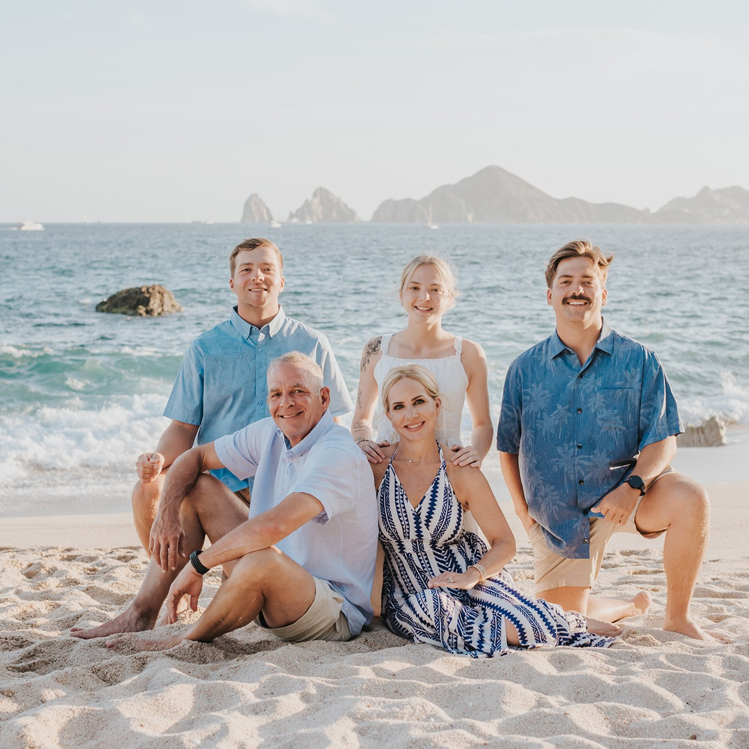 Family of six at sunset on Los Cabos beach, with the Arch and Finisterra in the background