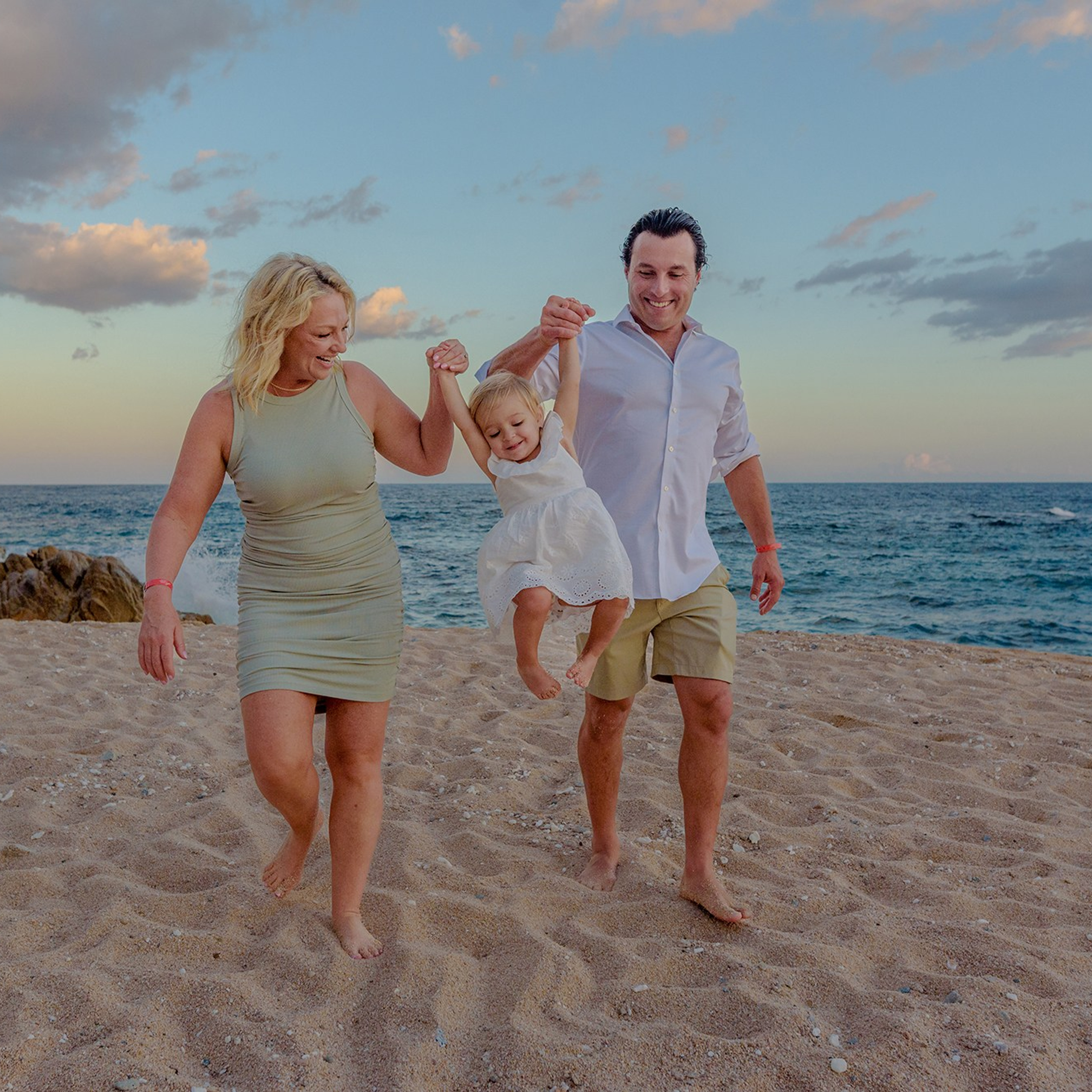 Parents with their little girl on the beach in Los Cabos