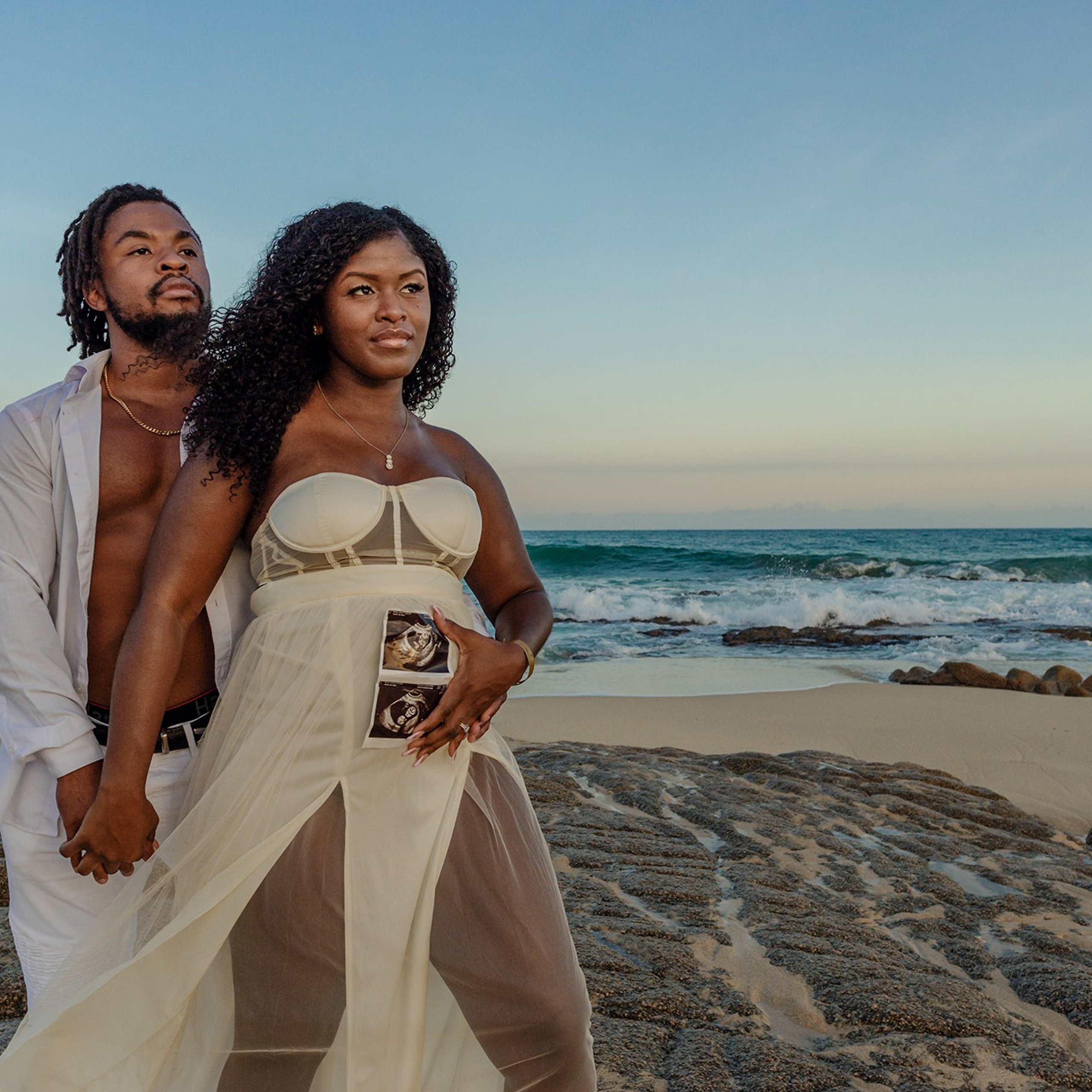 Maternity portrait in Cabo – pregnant woman surrounded by ocean and palm trees, symbolizing the magic of motherhood and the love of awaiting new life