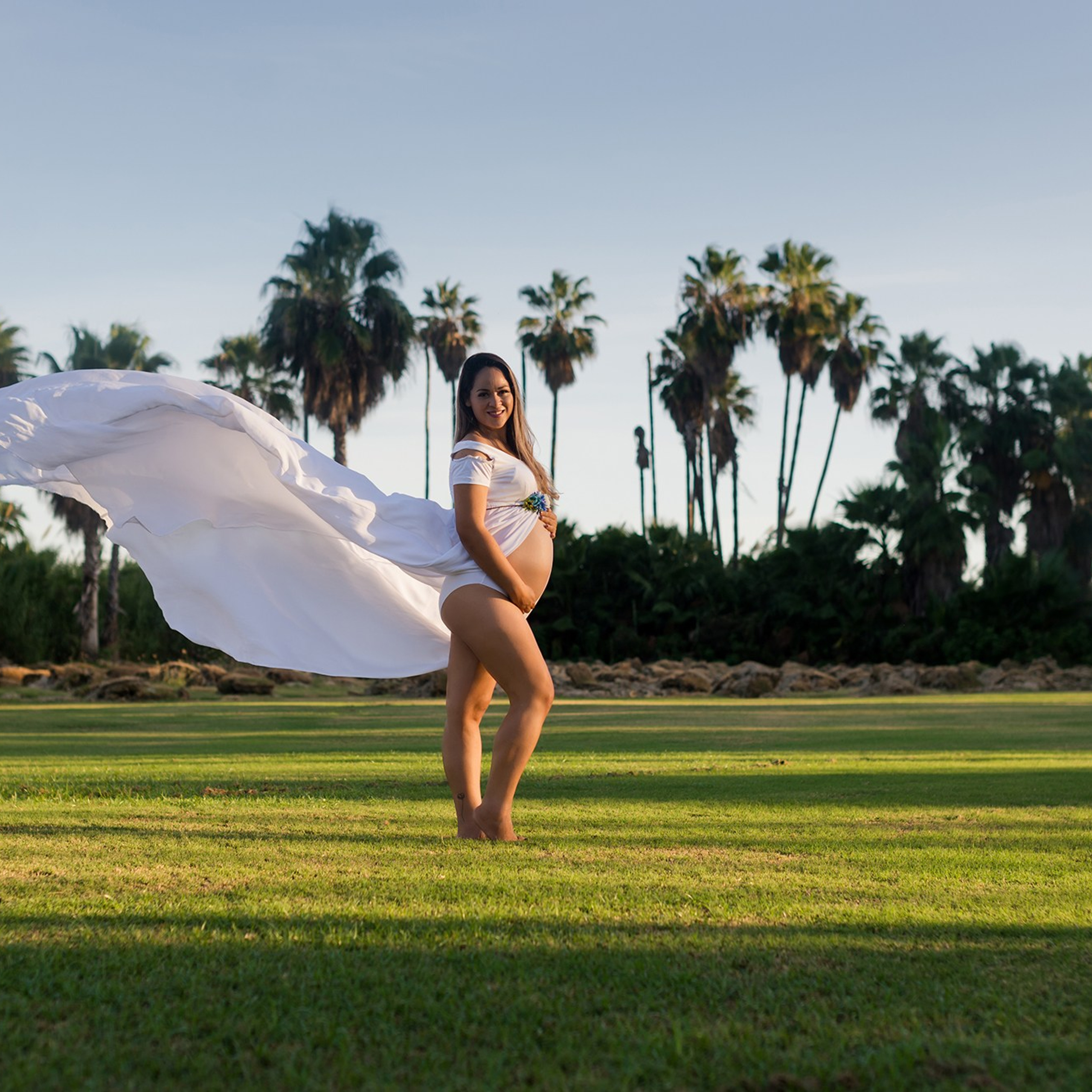 Maternity portrait in Los Cabos – pregnant woman looking at the camera with natural light, ocean and beach in the background, captured by Cabo maternity photographer